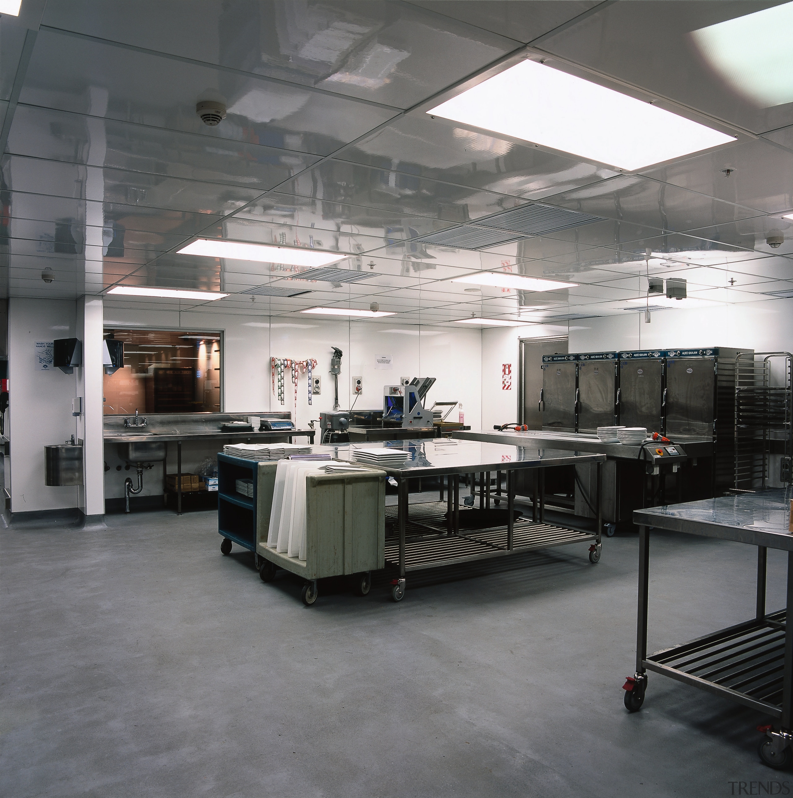 Commercial kitchen with stainless steel equipment and grey factory, floor, gray