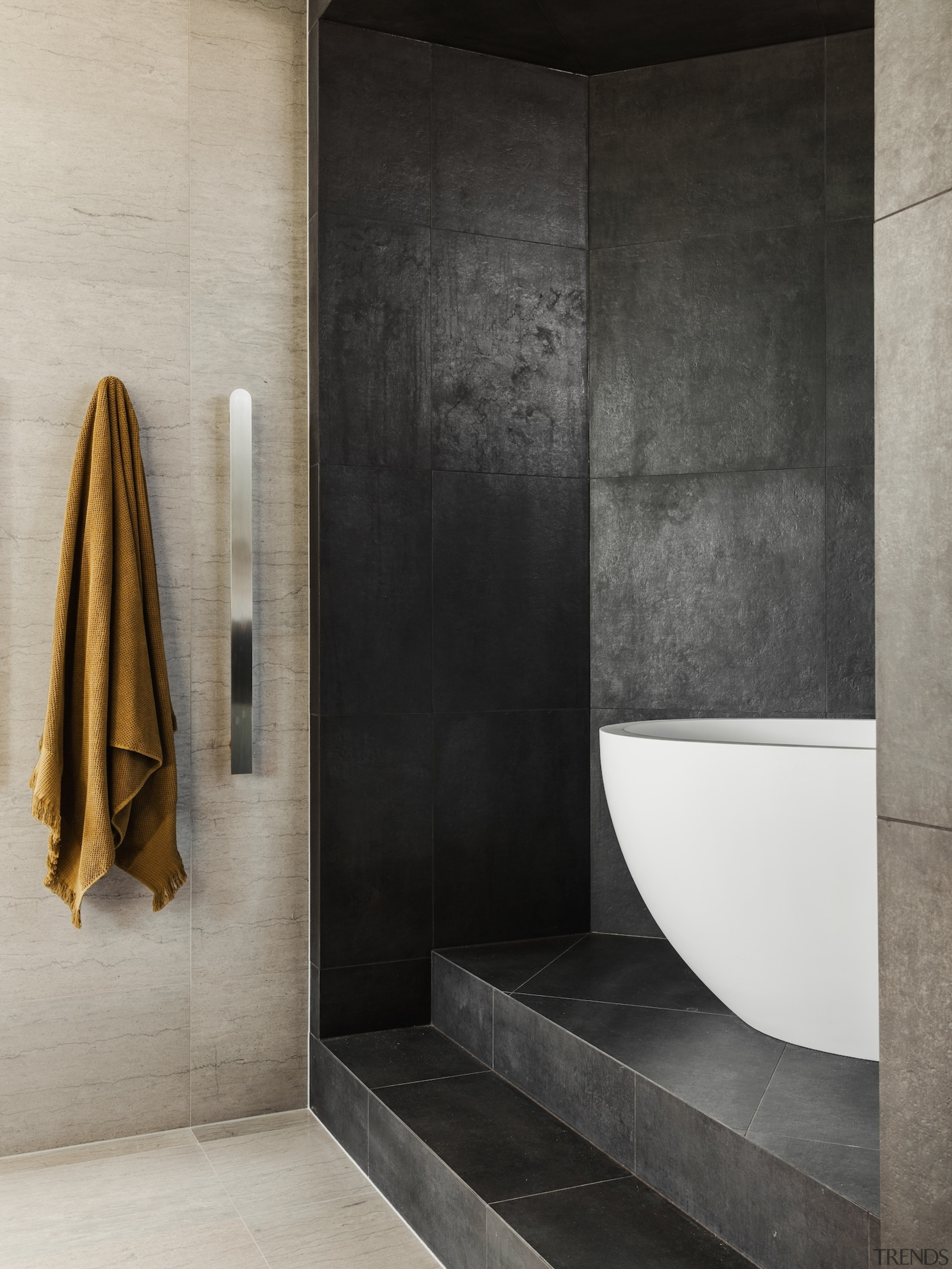 The freestanding bath sits on a raised podium, 