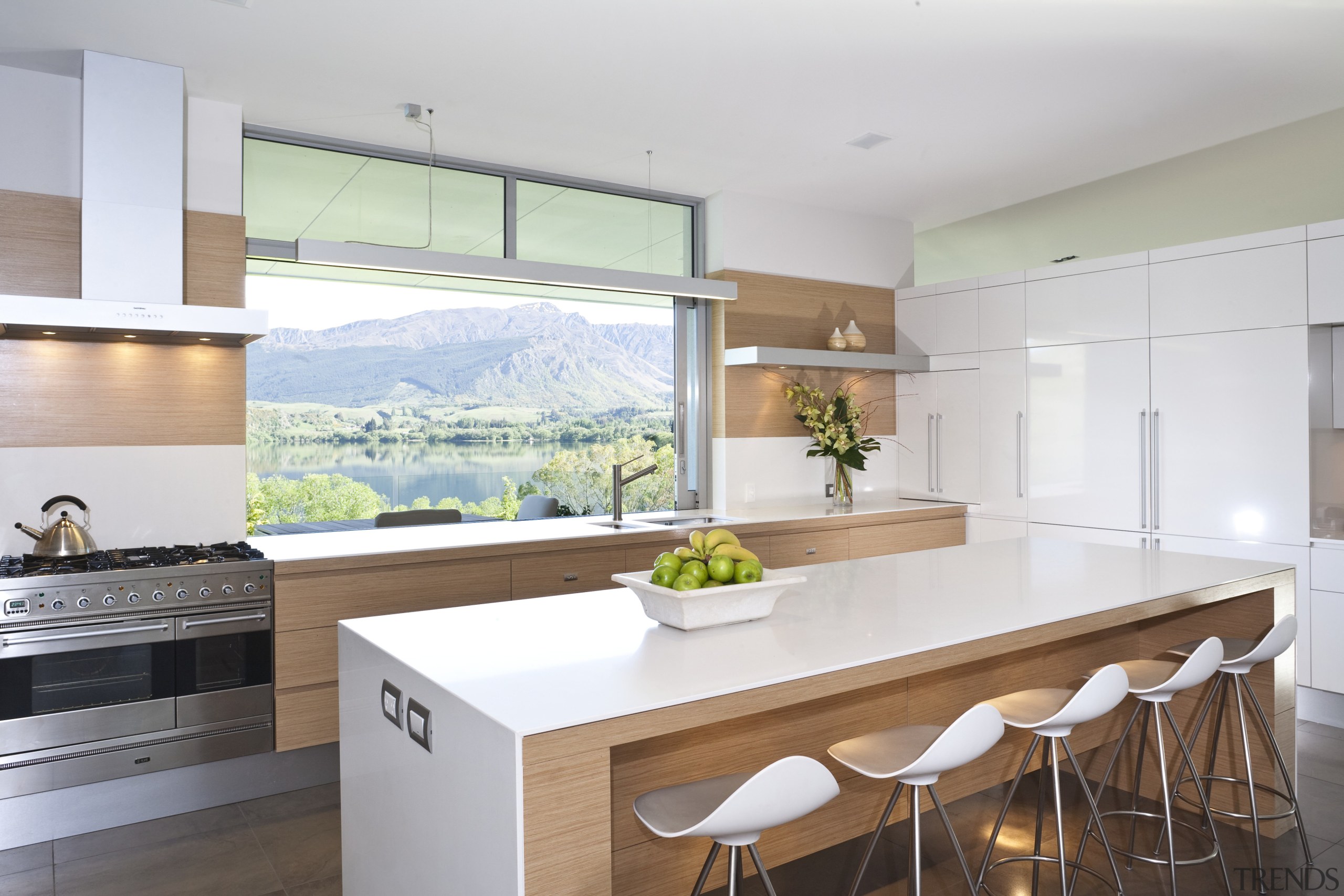 View of kitchen and living area featuring light architecture, countertop, house, interior design, kitchen, real estate, window, white