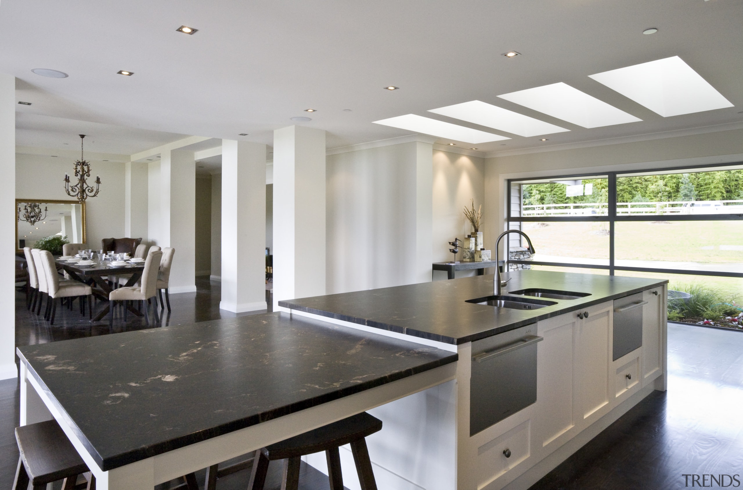 View of a kitchen which features a black countertop, estate, floor, house, interior design, kitchen, property, real estate, window, gray