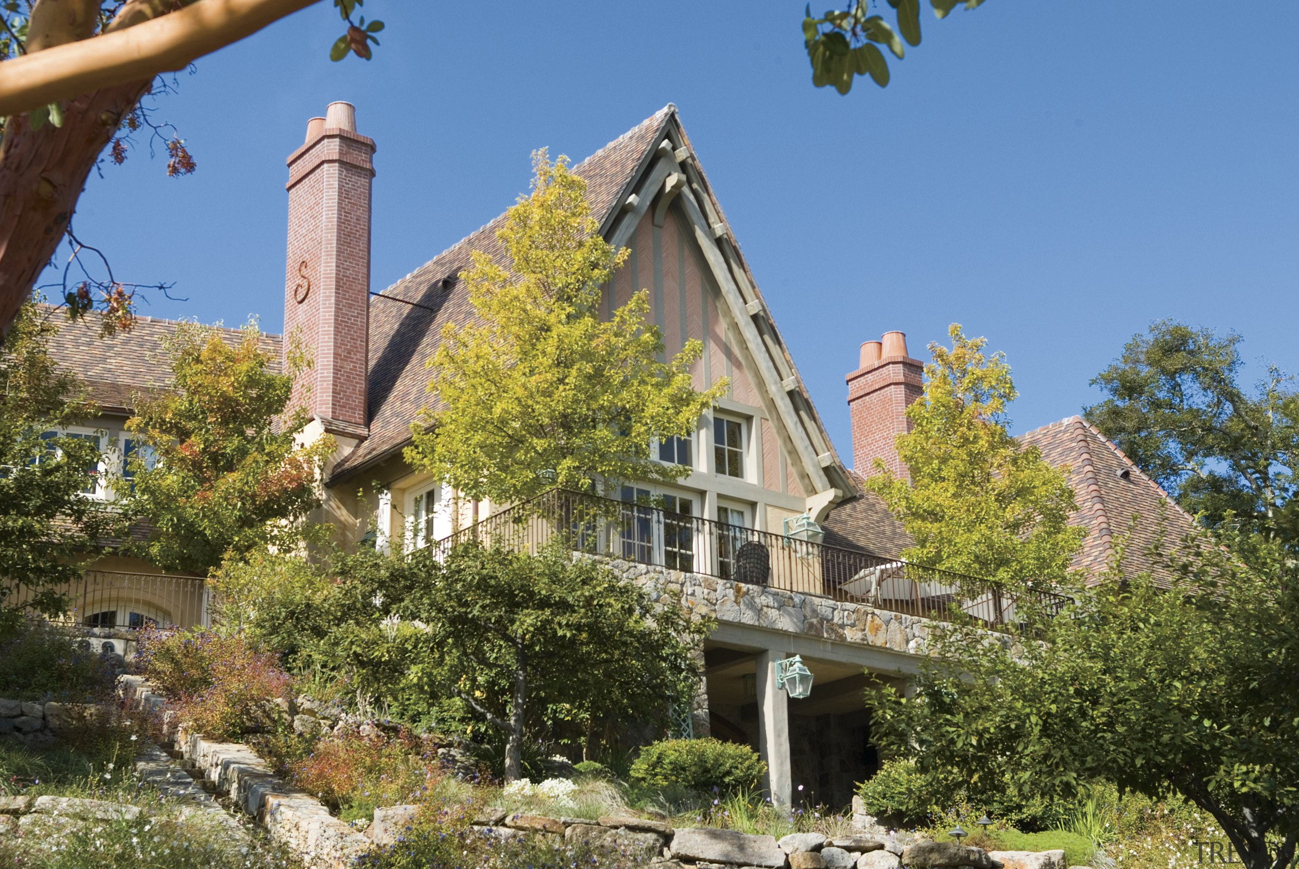 View of exterior of house, clay tile roof, building, cottage, estate, facade, home, house, mansion, plant, property, real estate, sky, tree, villa, brown, teal