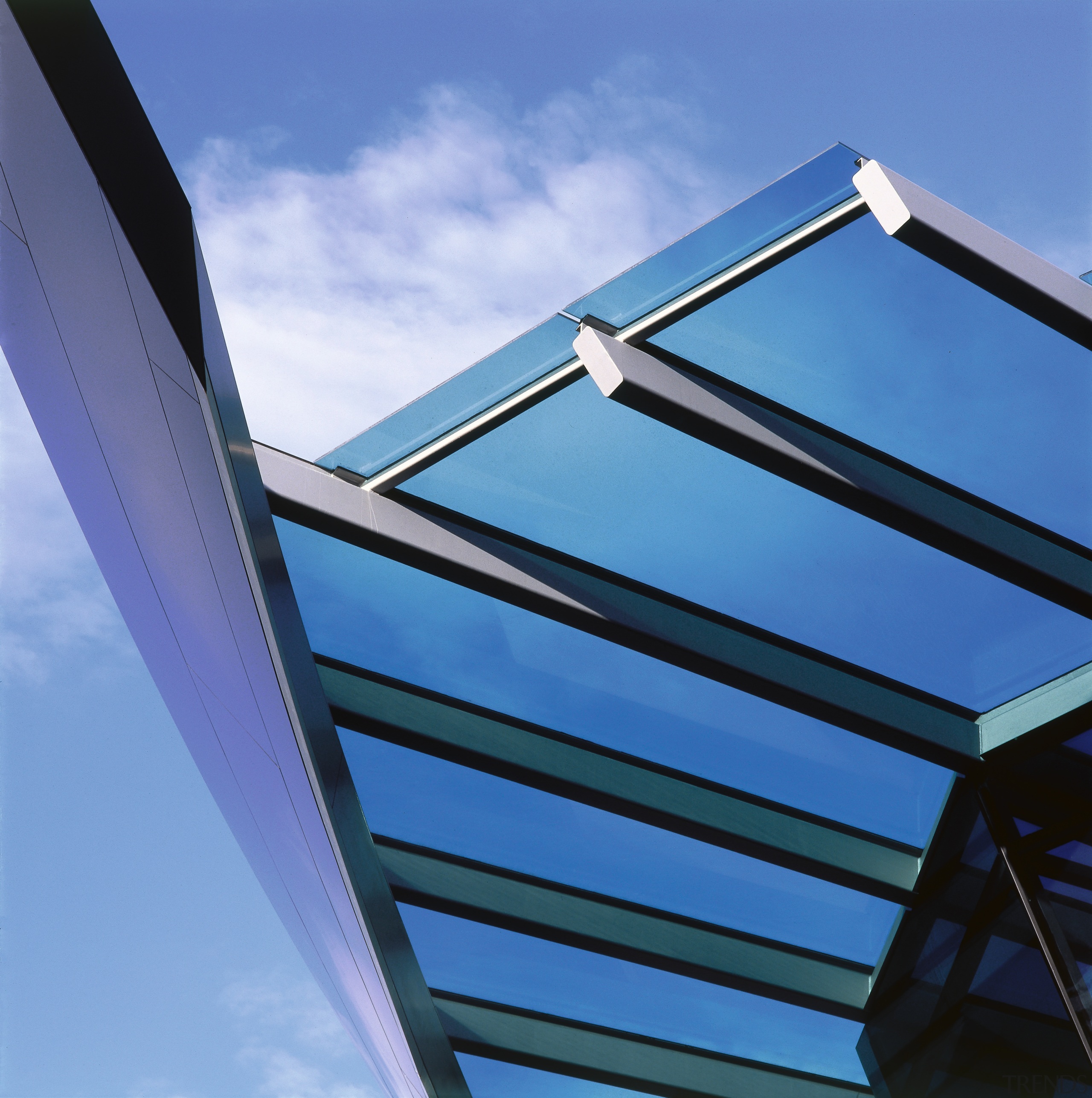 View of glass canopy covering entranceway of apartment angle, architecture, building, cloud, daylighting, daytime, facade, line, sky, structure, blue