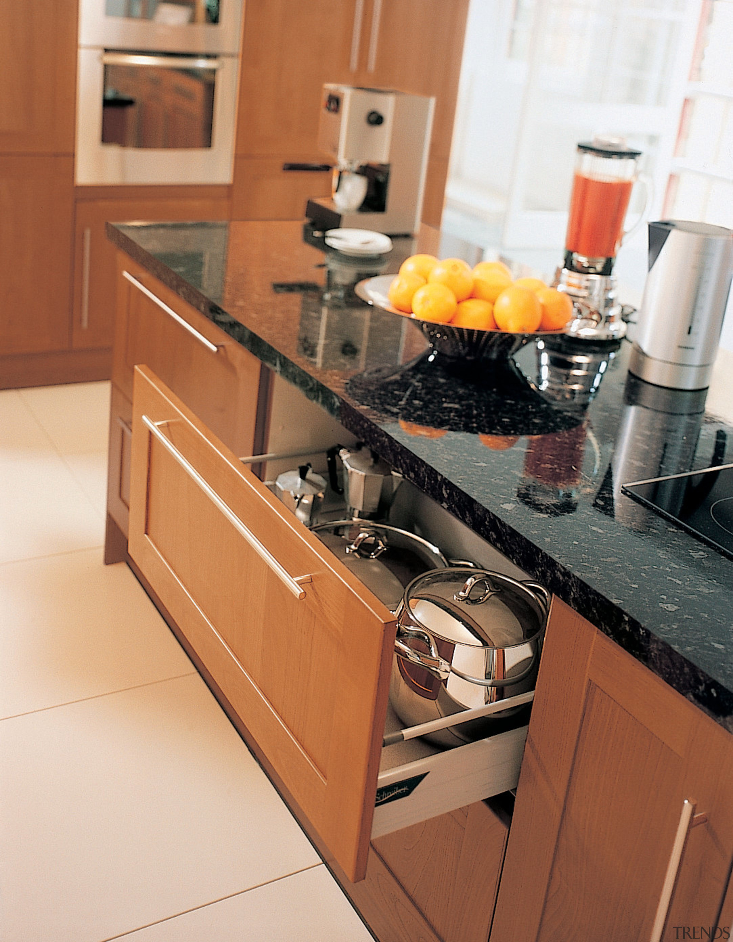 A view of a kitchen, wooden cabinetry, white cabinetry, countertop, cuisine classique, drawer, floor, flooring, furniture, hardwood, home appliance, interior design, kitchen, kitchen appliance, kitchen stove, room, tile, brown, orange, white