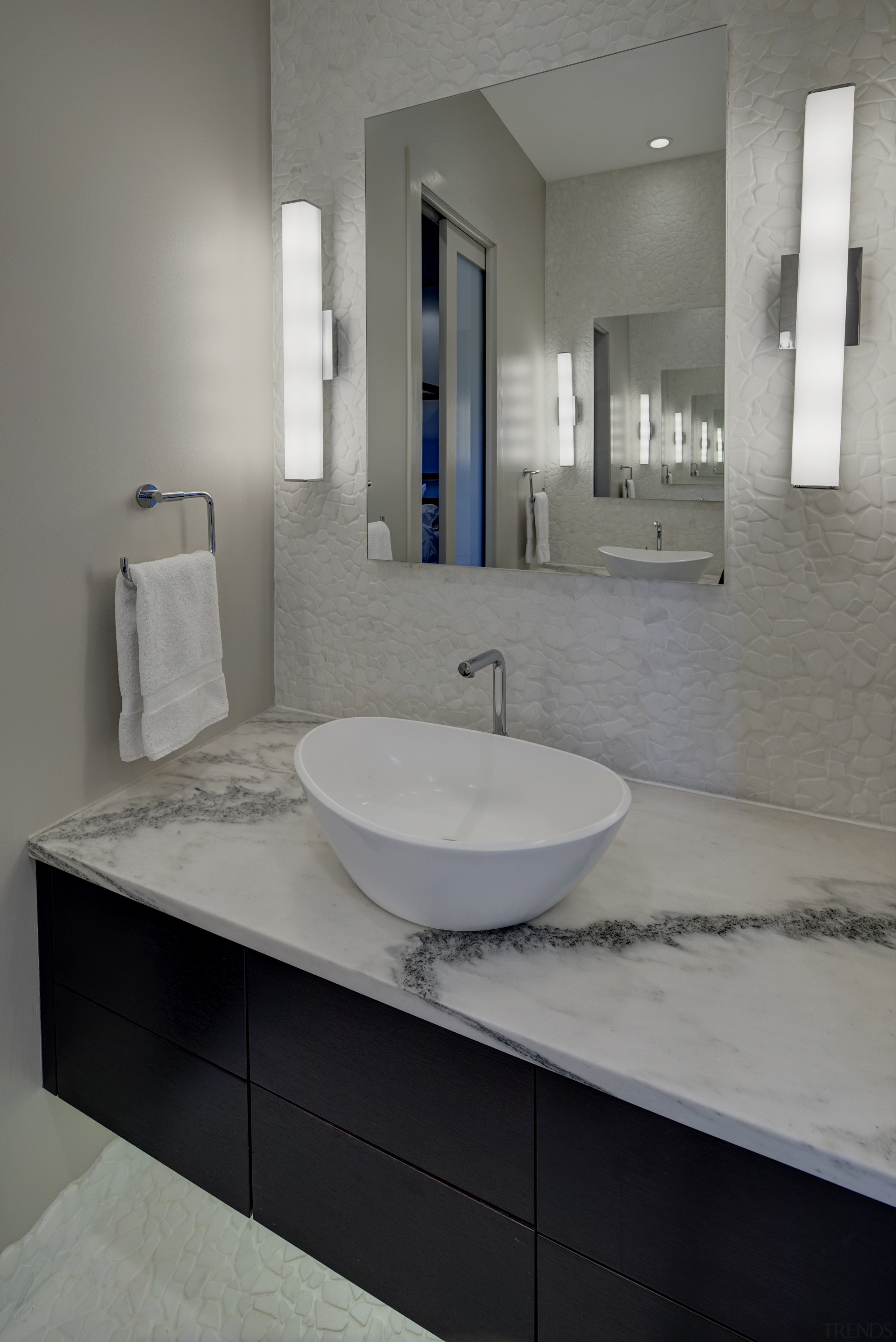 Textural white rock features on the floor of architecture, bathroom, bathroom accessory, bathroom cabinet, floor, interior design, plumbing fixture, product design, room, sink, tap, gray