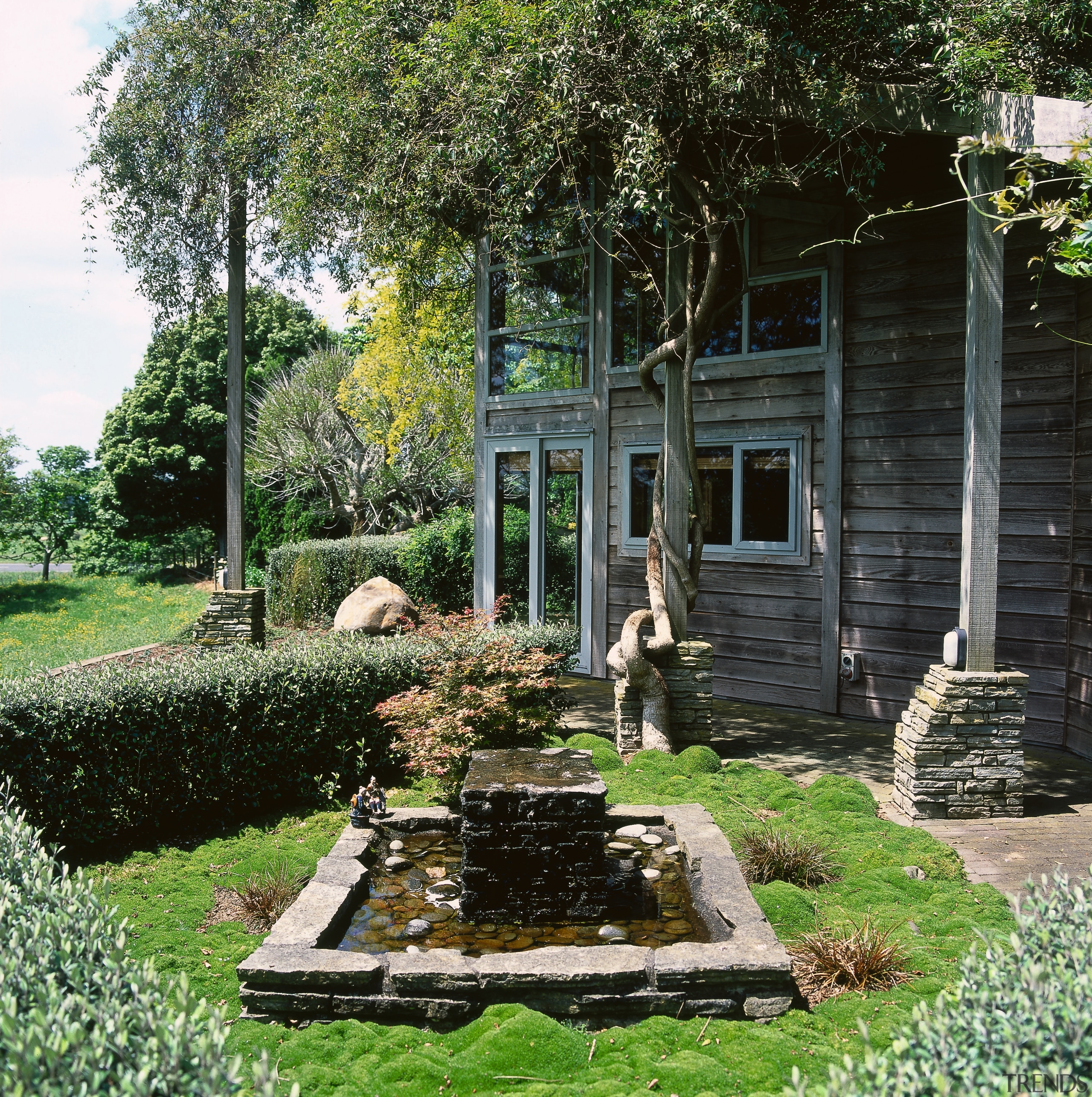 a pool water feature in this garden are backyard, cottage, estate, garden, grass, home, house, landscape, landscaping, outdoor structure, plant, tree, yard, black, green