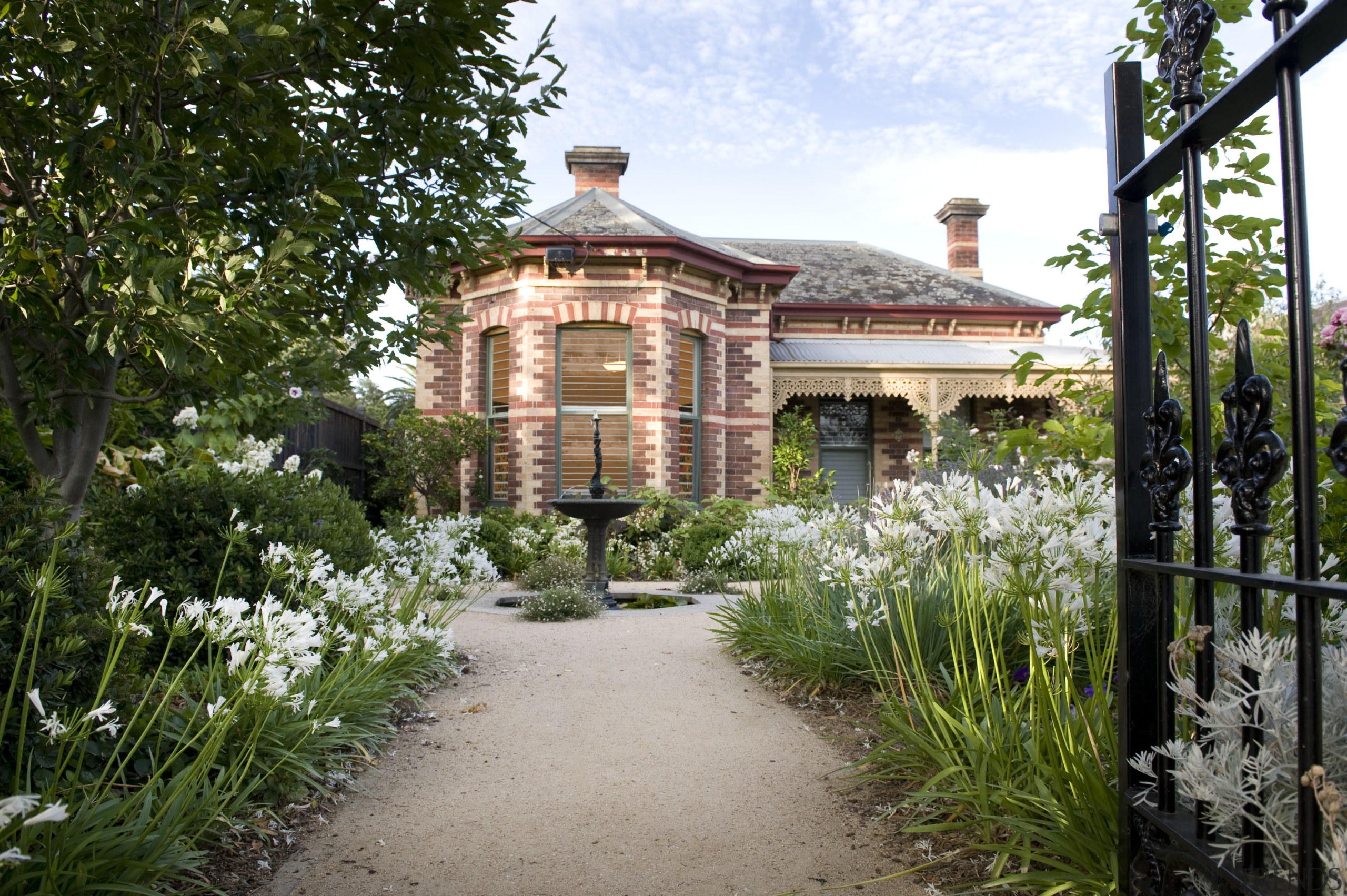 Exterior view of a villa with newly renovated botanical garden, cottage, estate, flower, garden, home, house, landscaping, mansion, outdoor structure, plant, property, real estate, walkway, brown