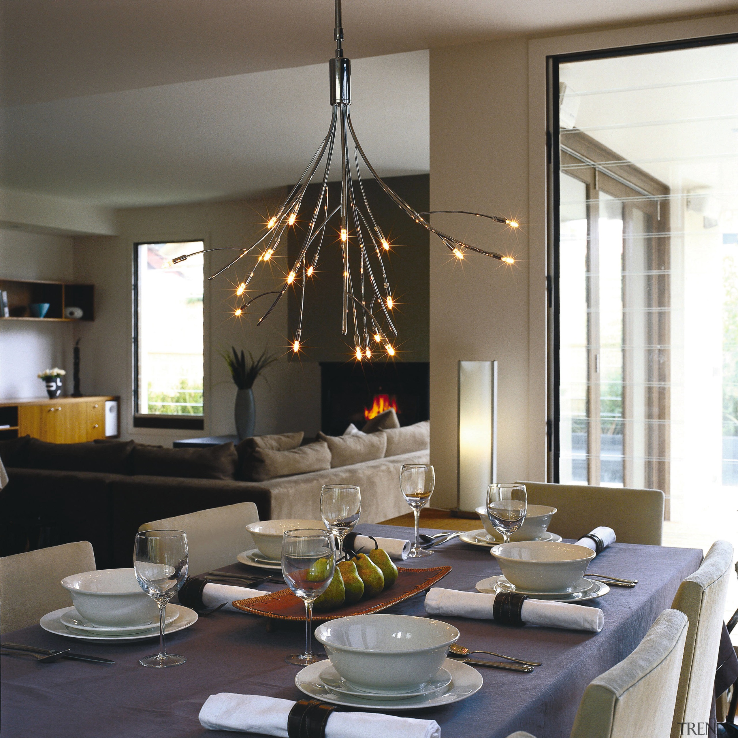 Ornate light fitting over dining room setting. - chandelier, dining room, furniture, home, interior design, light fixture, lighting, living room, room, table, gray, black