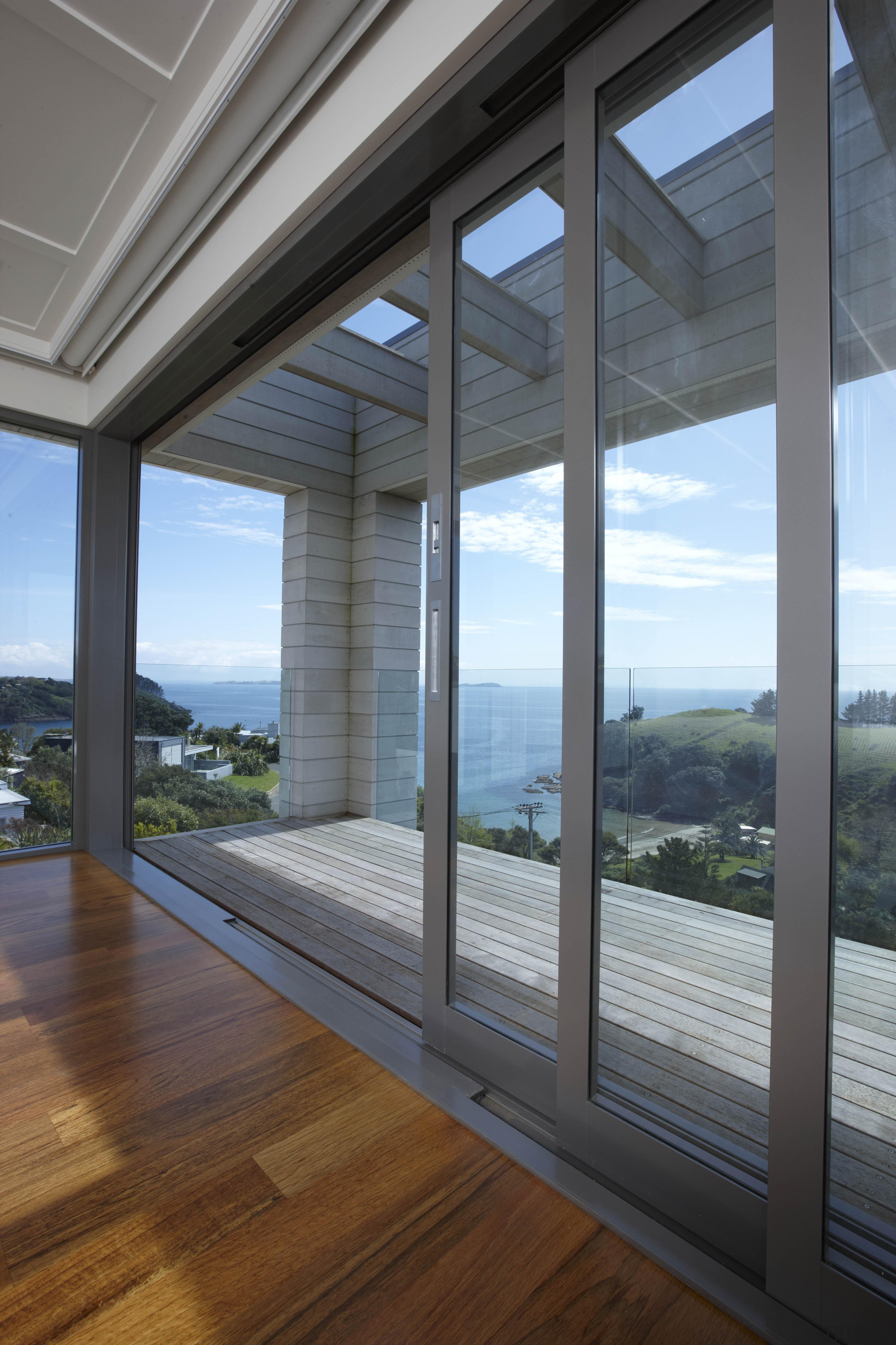 Large sliding doors disappear to reveal breathtaking sea architecture, daylighting, door, home, house, interior design, real estate, structure, window, gray