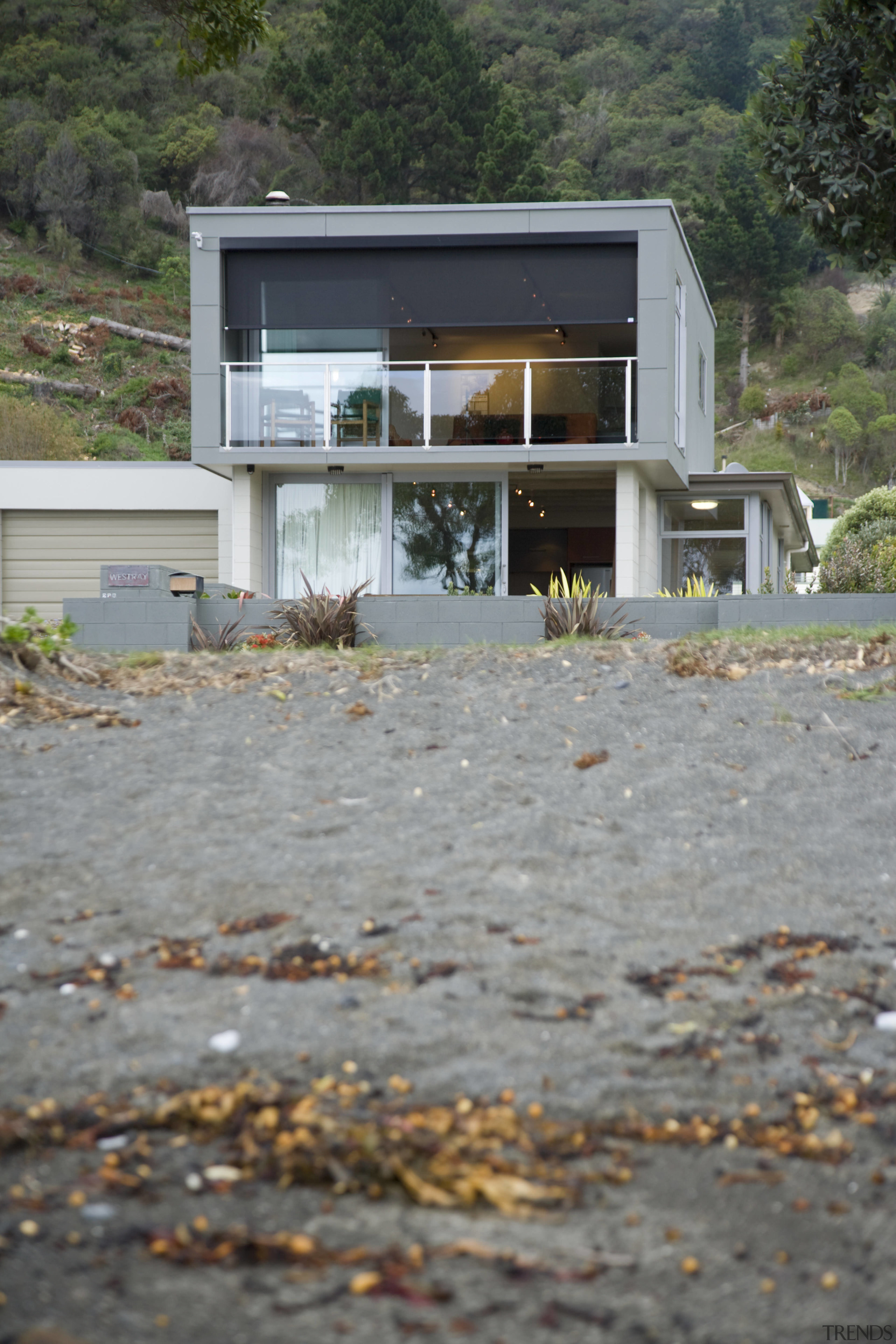 With a long, narrow design, this two-storey bach architecture, cottage, home, house, real estate, roof, water, gray