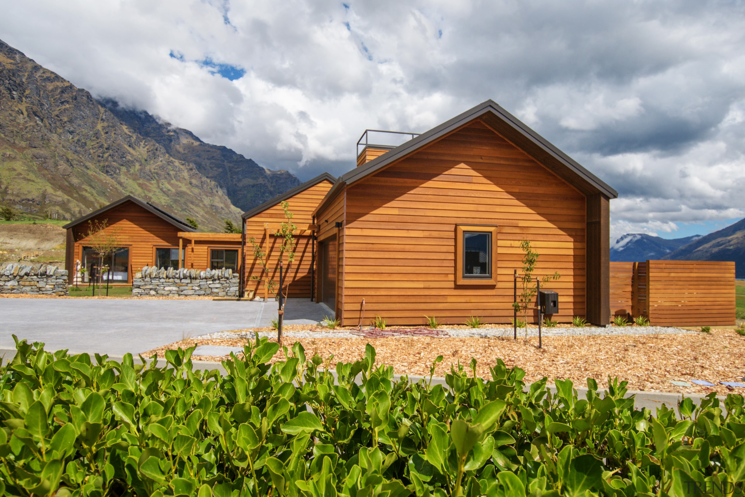 This new home is visually enticing in its cottage, elevation, facade, farmhouse, home, house, hut, land lot, landscape, log cabin, mountain, property, real estate, roof, rural area, sky, gray, brown