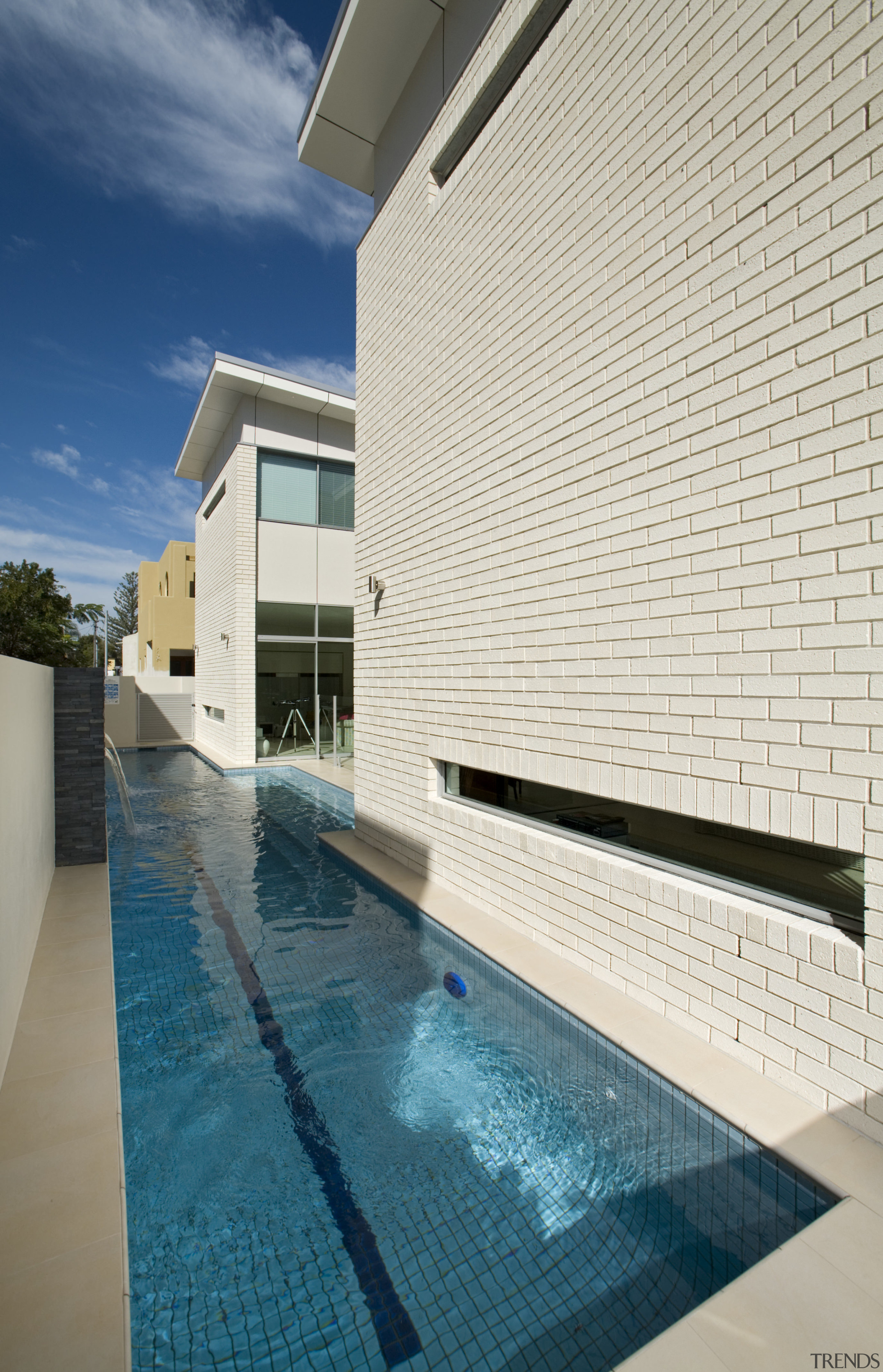 Side view of brick wall with a paved architecture, building, condominium, daylighting, estate, facade, home, house, leisure centre, property, real estate, sky, swimming pool, white