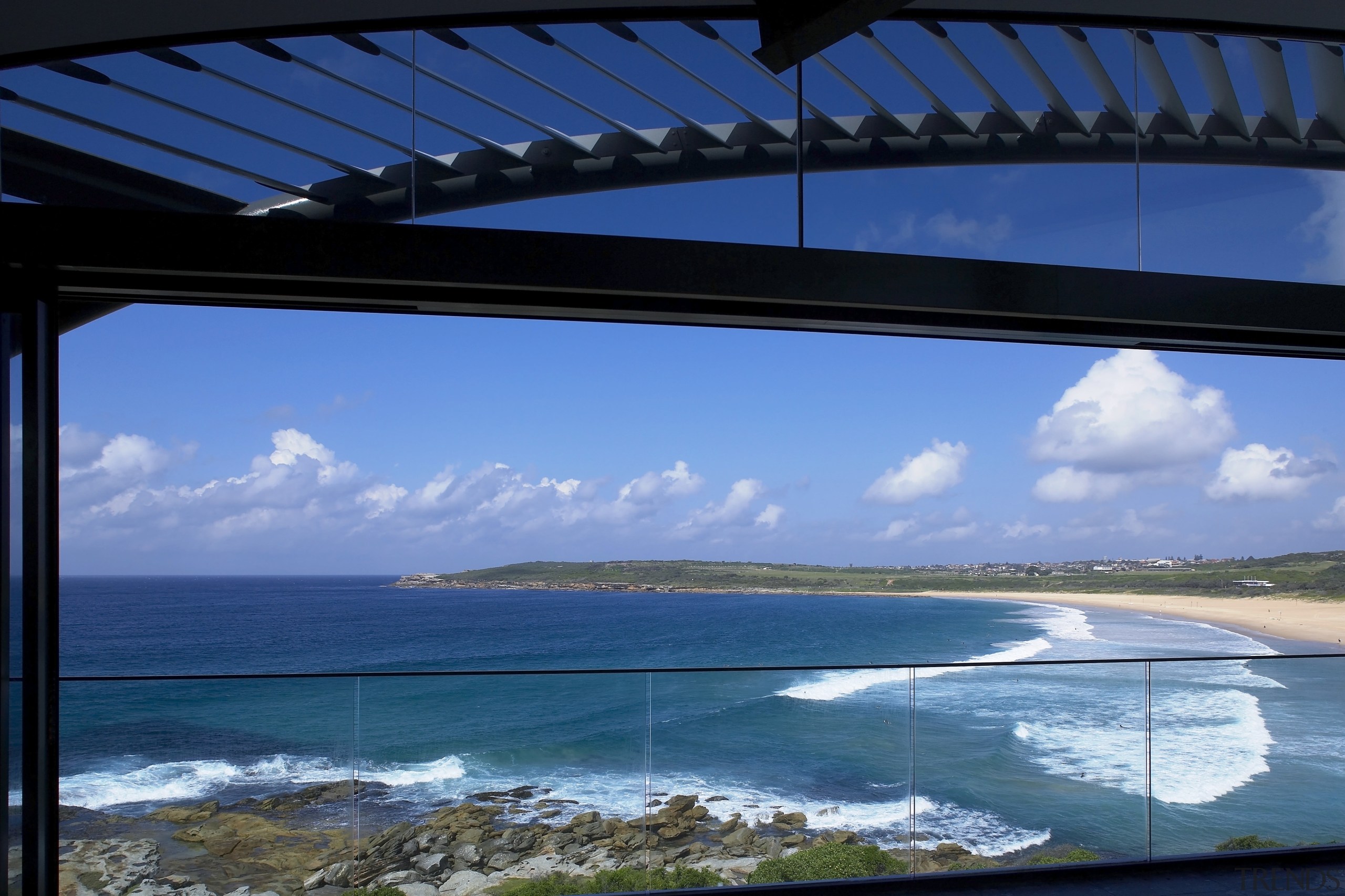 View of an apartment balcony which features glass cloud, fixed link, sea, sky, water, teal, blue