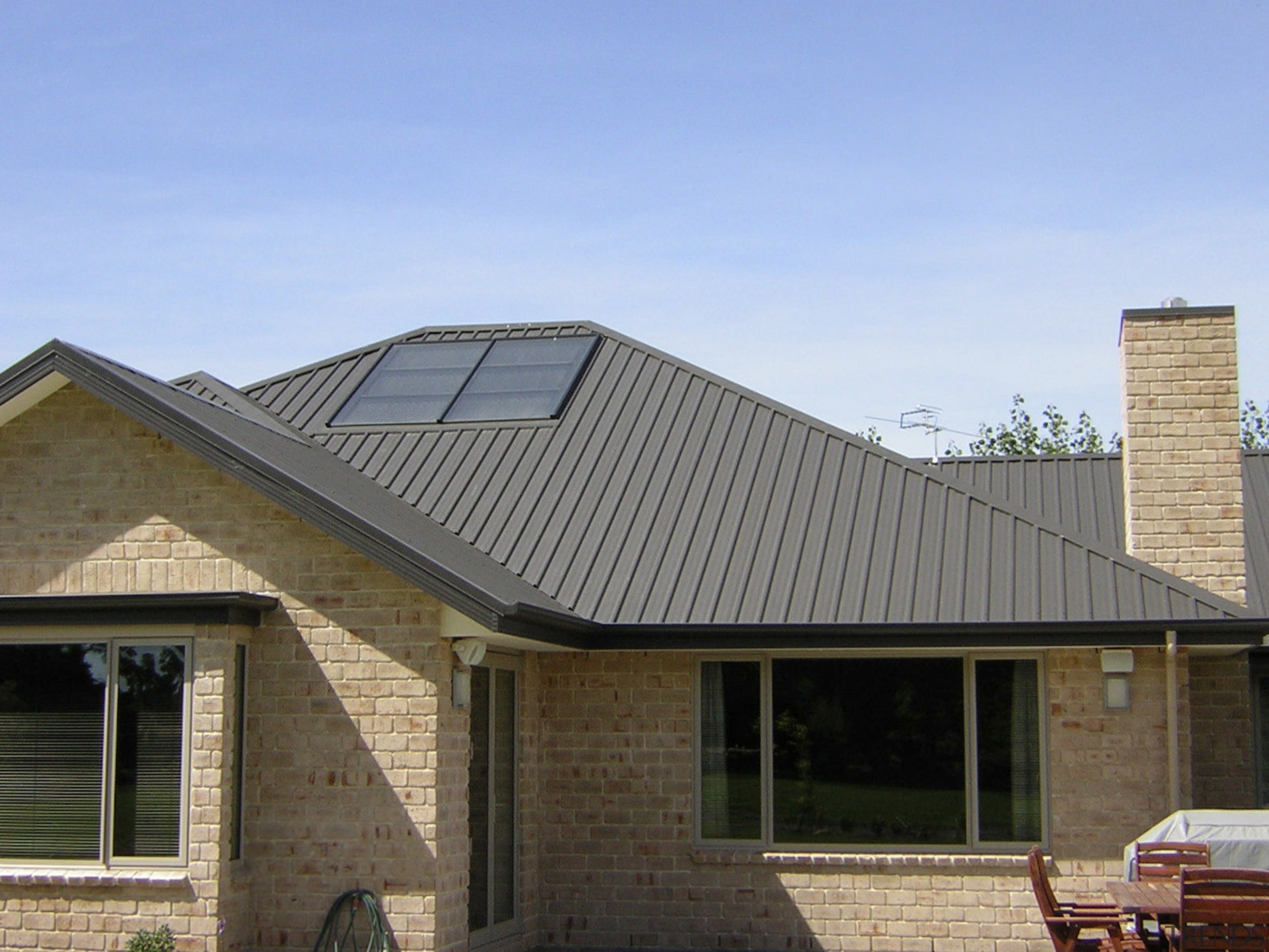 This large home efficiently uses solar energy thanks daylighting, elevation, facade, home, house, outdoor structure, property, real estate, residential area, roof, siding, window, teal