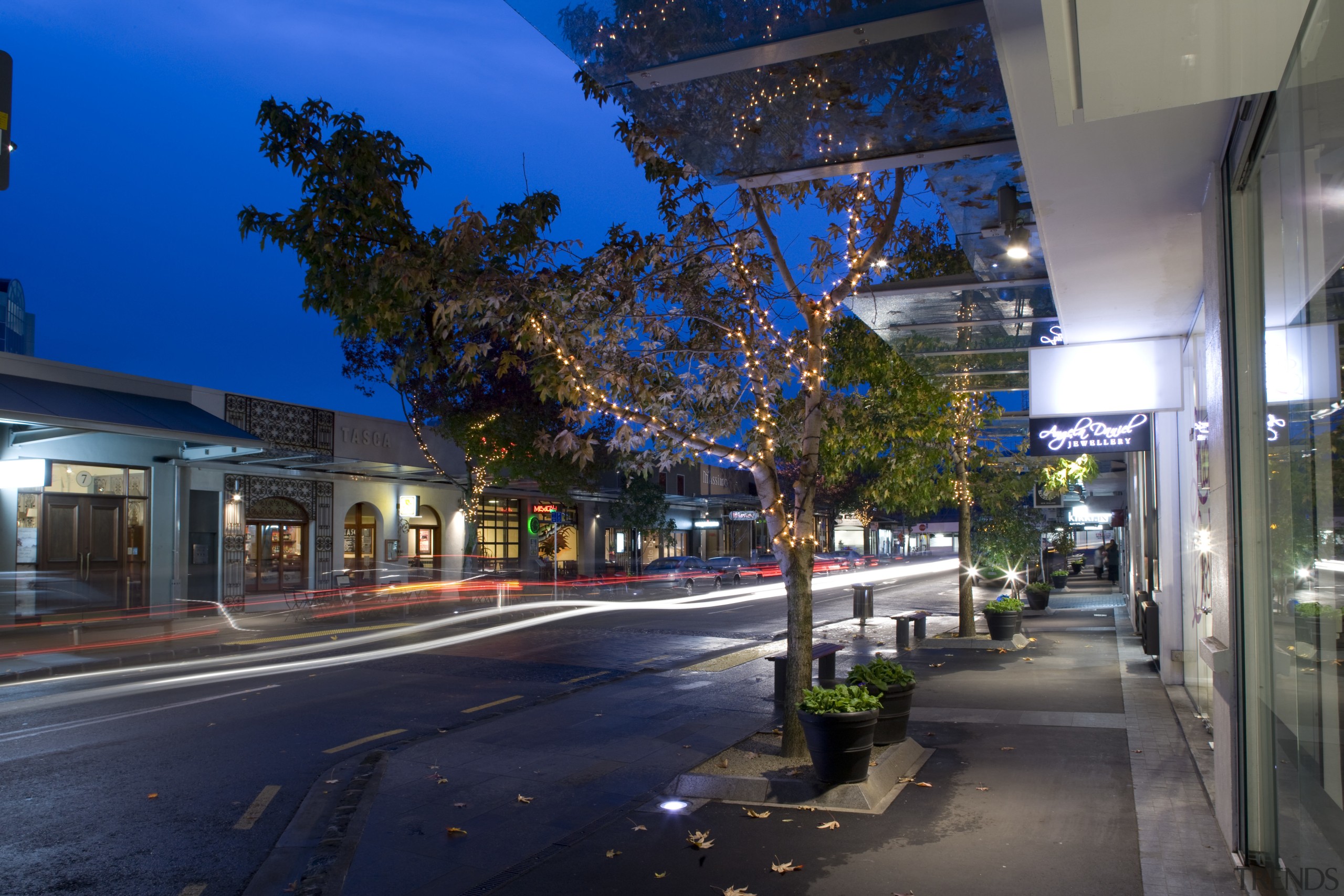 Image of the Trinity Apartments designed by the architecture, building, city, cityscape, downtown, evening, house, infrastructure, metropolis, metropolitan area, mixed use, neighbourhood, night, plant, real estate, residential area, road, sky, street, street light, suburb, town, tree, urban area, blue