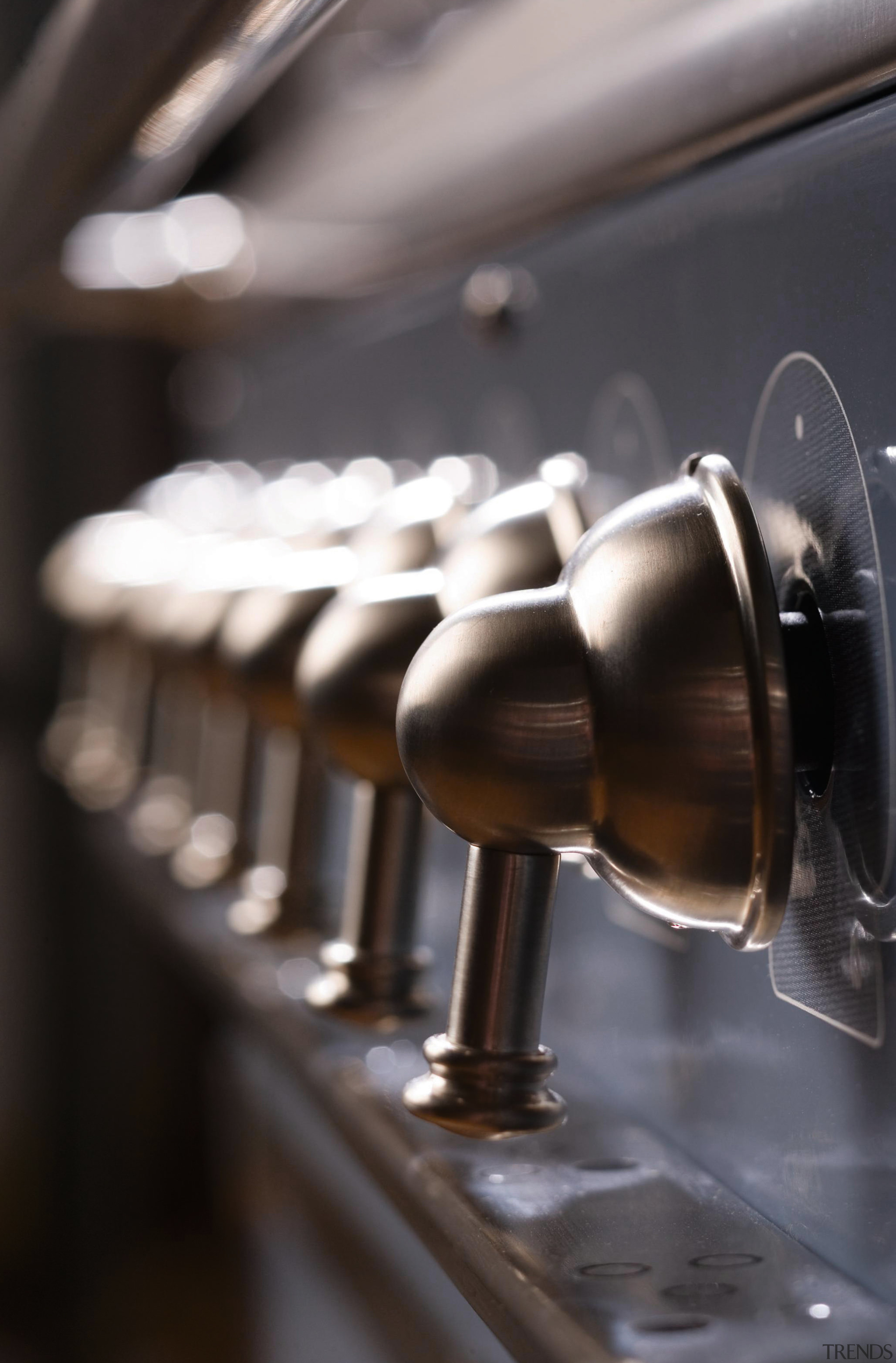 Closeup view of control handles for oven range. automotive design, metal, black, gray