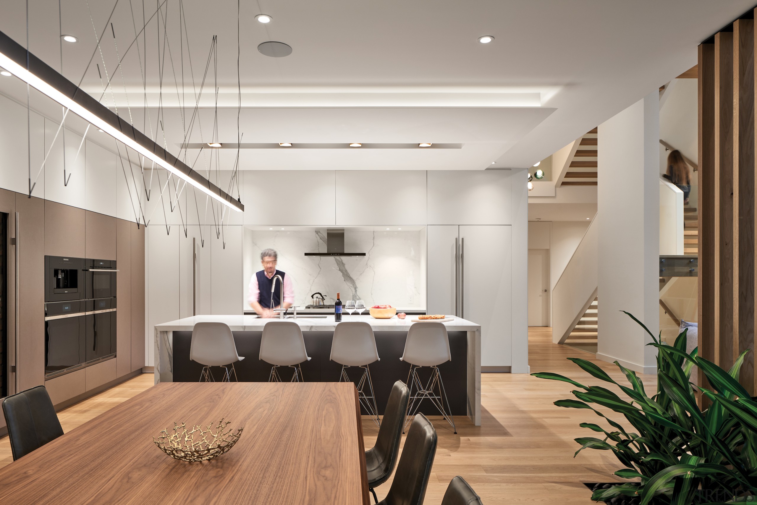 Kitchen and dining rooms with open staircase in 