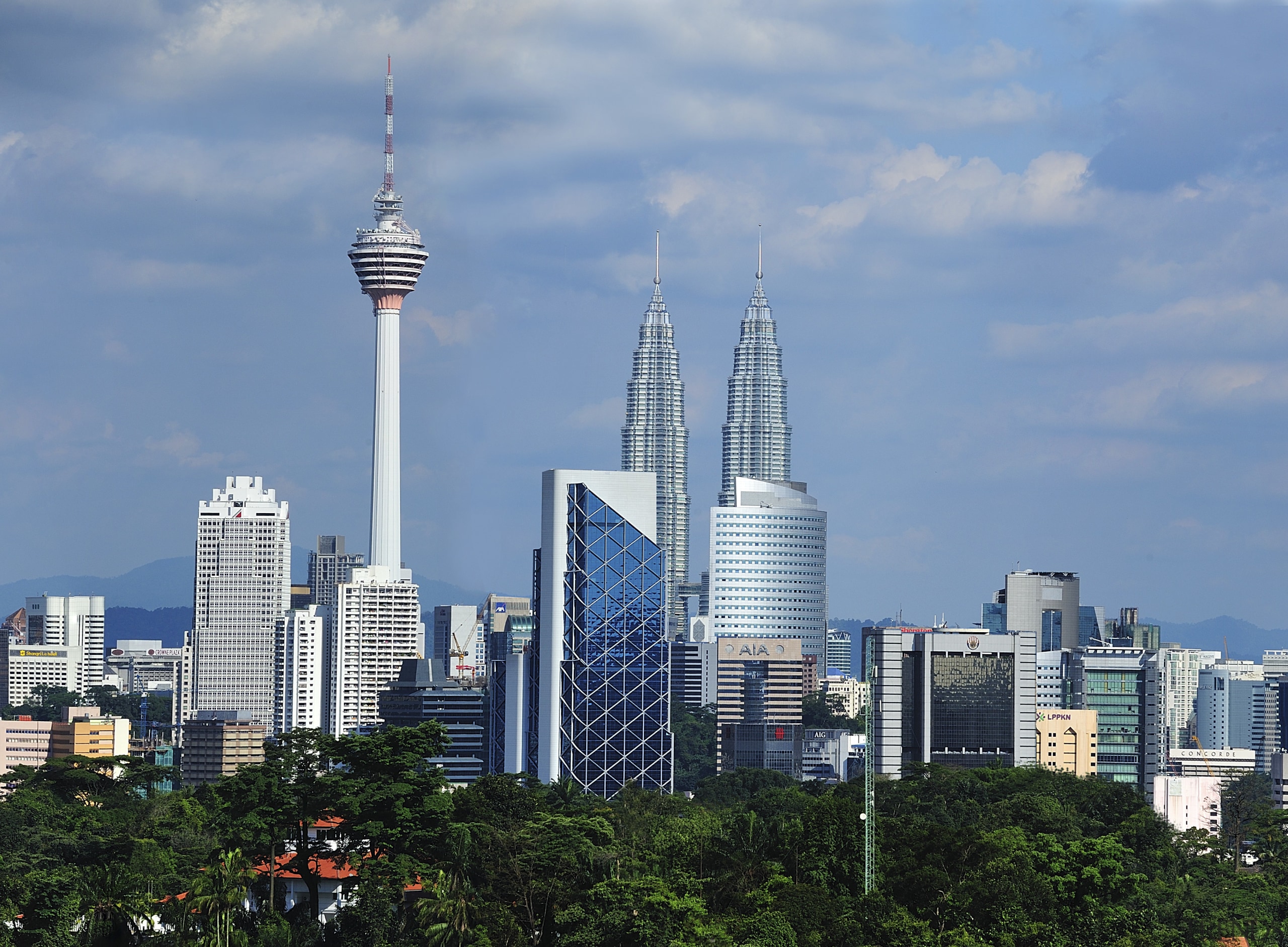 The new Menara Bumiputra Commerce tower is appropriate building, city, cityscape, cloud, condominium, daytime, downtown, landmark, metropolis, metropolitan area, sky, skyline, skyscraper, tower, tower block, tree, urban area, teal