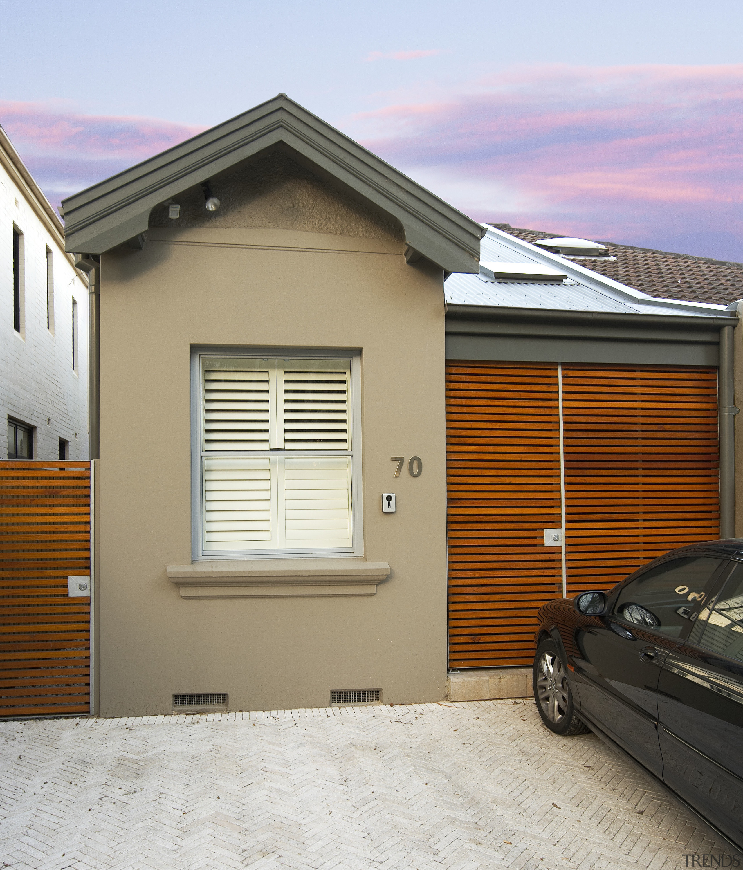 A glazed, three-storey atrium fills this home with building, door, facade, garage, garage door, home, house, property, real estate, residential area, siding, window