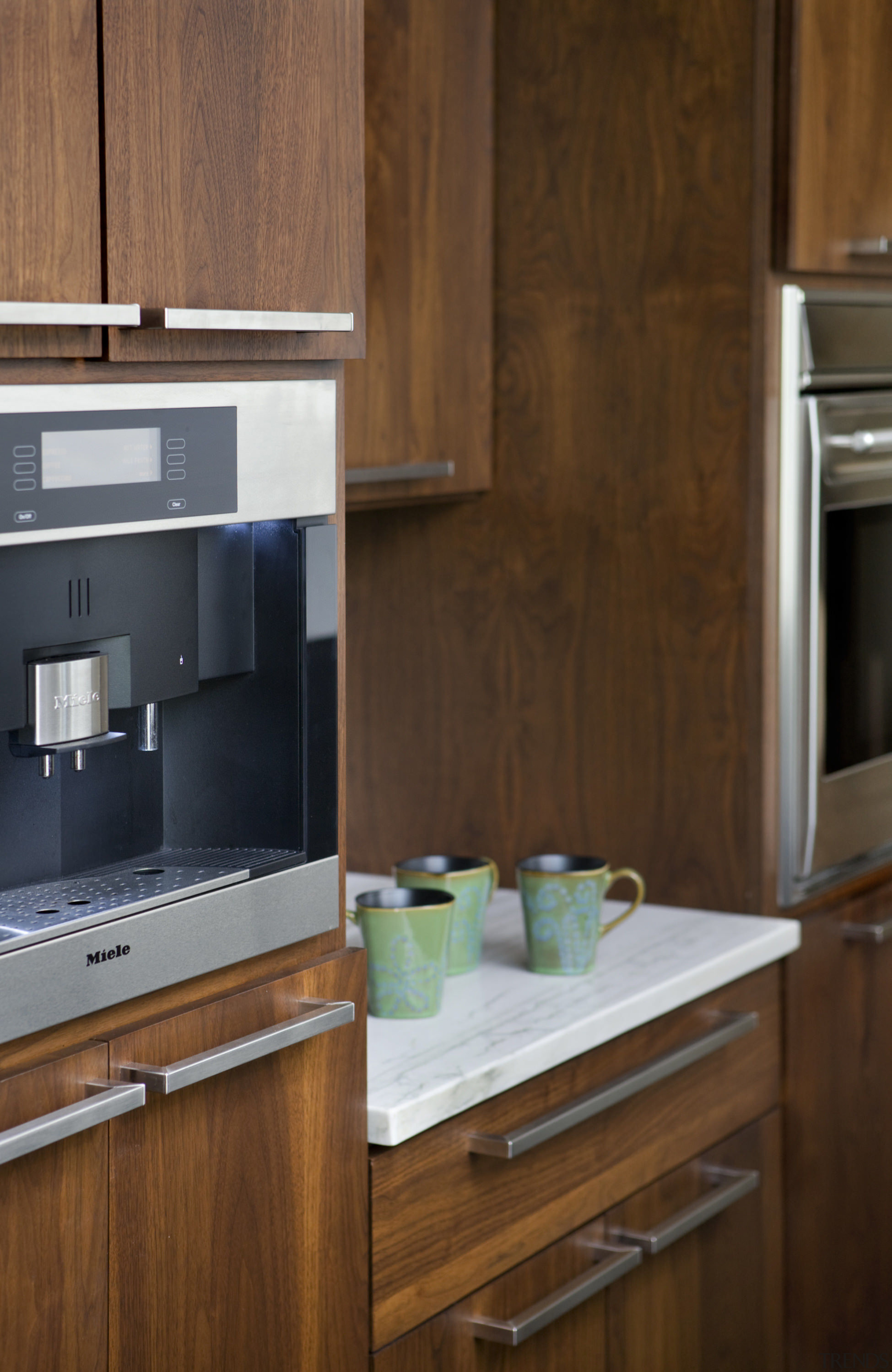 View of a kitchen which features white quartzite cabinetry, countertop, cuisine classique, furniture, hardwood, home appliance, kitchen, kitchen appliance, kitchen stove, room, under cabinet lighting, wood stain, brown