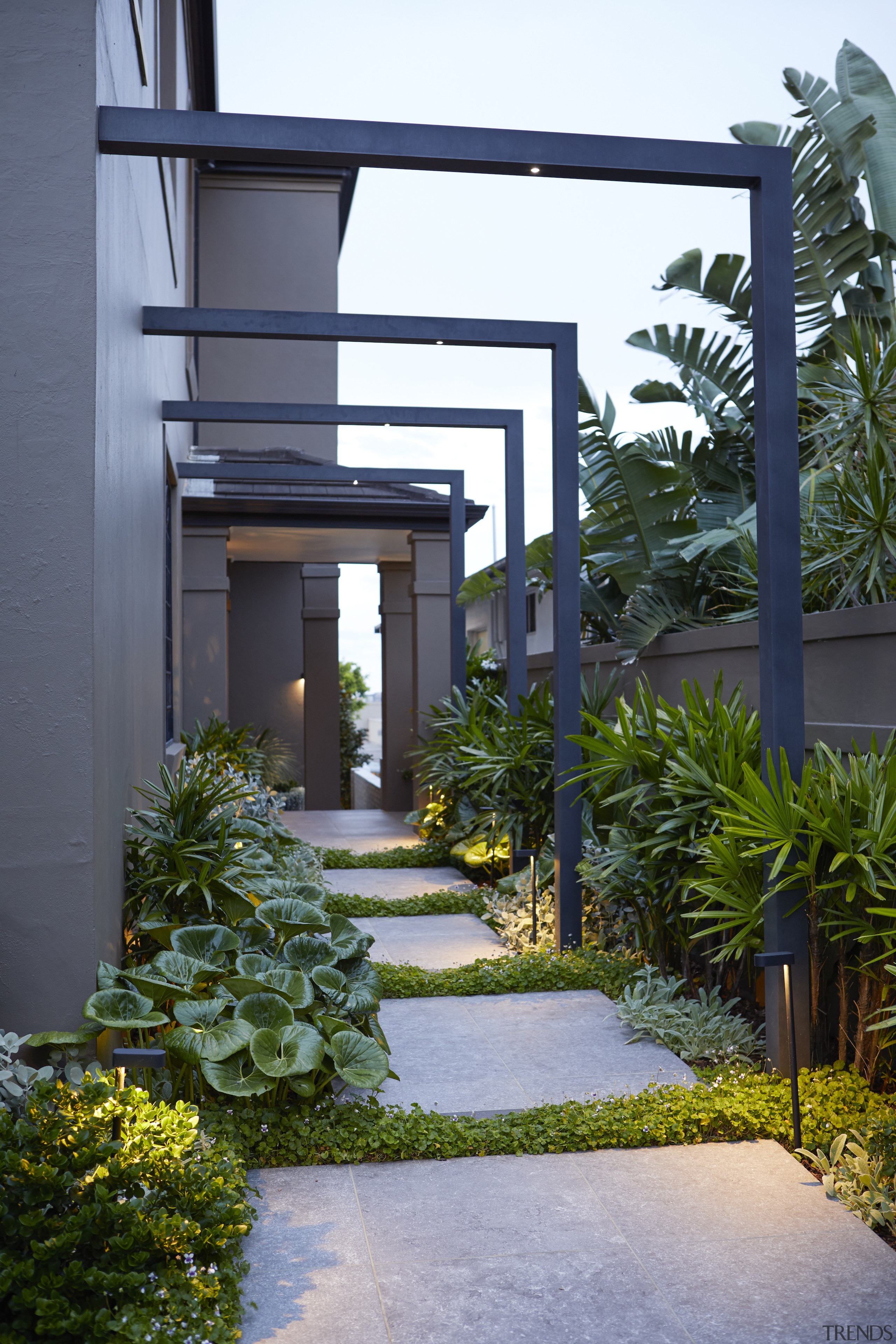 Side path with pavers and metal arbours connecting 