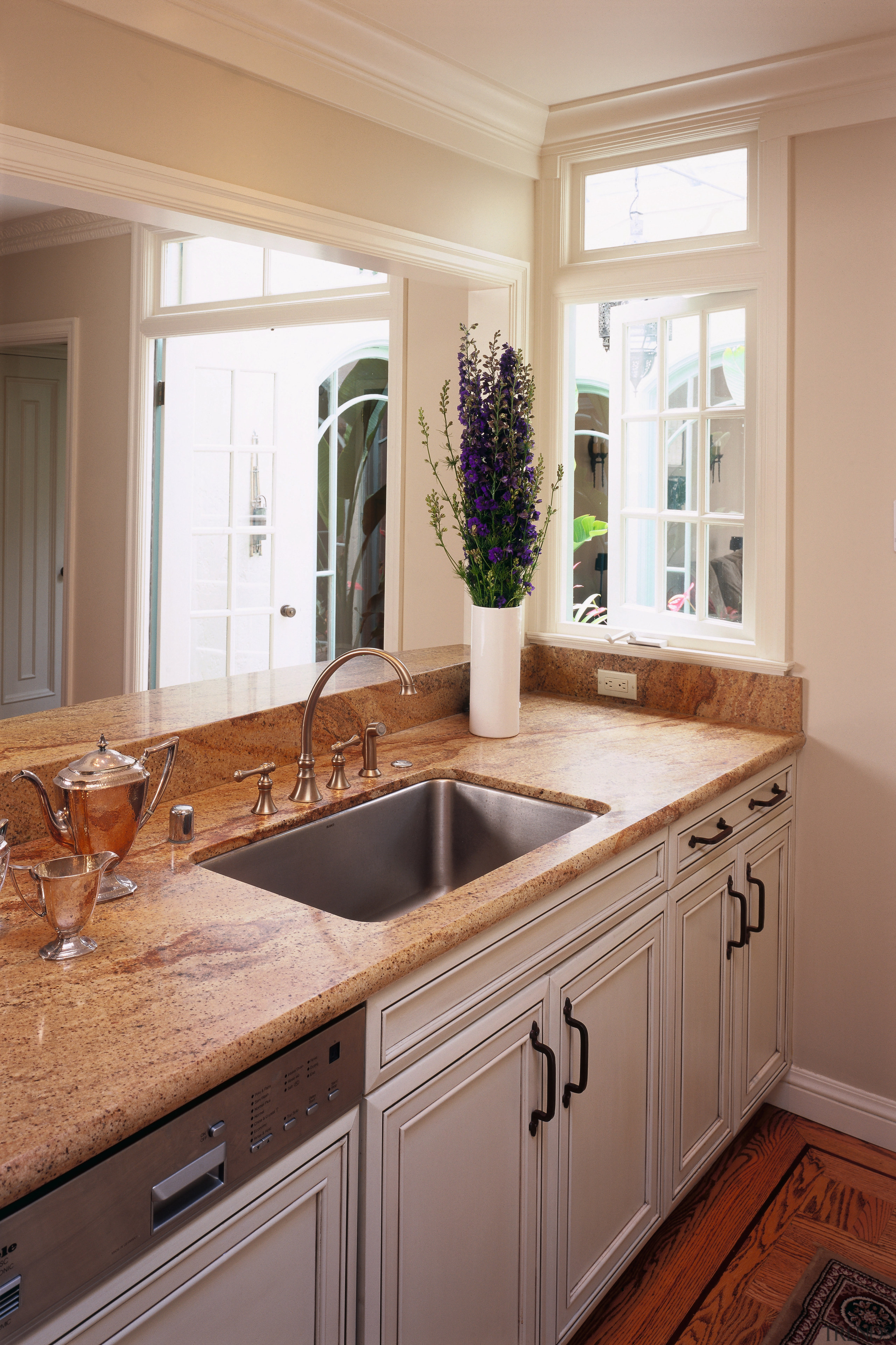 view of the kitchen featuring limestone countertop, timber cabinetry, countertop, cuisine classique, floor, flooring, home, interior design, kitchen, room, sink, window, gray, brown