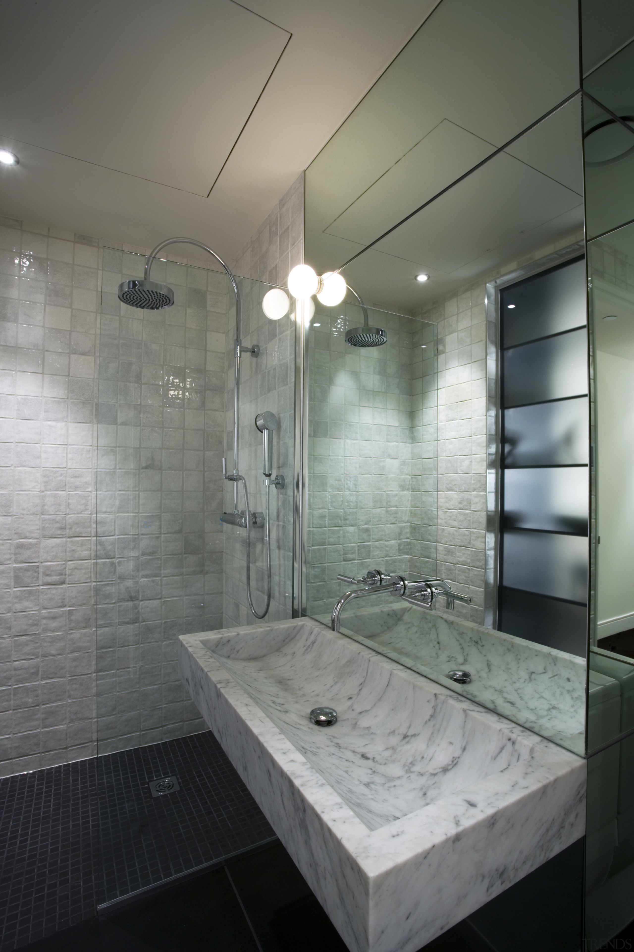 A view of the bathroom featuring tiled flooring, architecture, bathroom, ceiling, daylighting, floor, glass, interior design, plumbing fixture, room, tile, wall, gray
