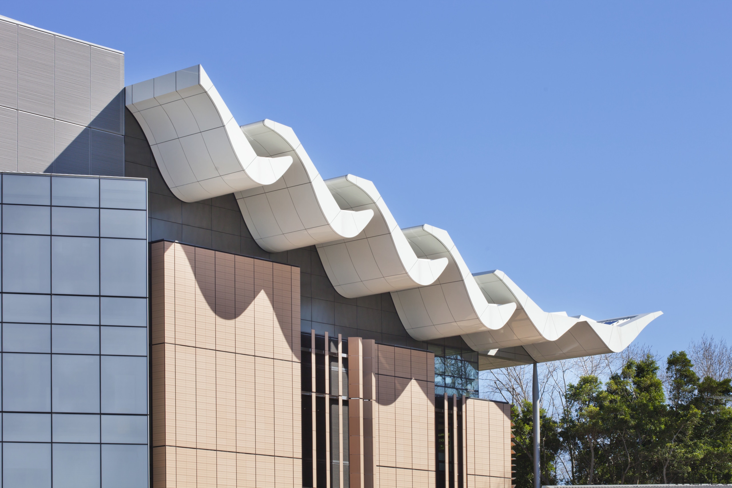 Viewed from the side, the sawtooth roof of architecture, building, daylighting, daytime, facade, home, house, property, real estate, residential area, roof, sky, teal