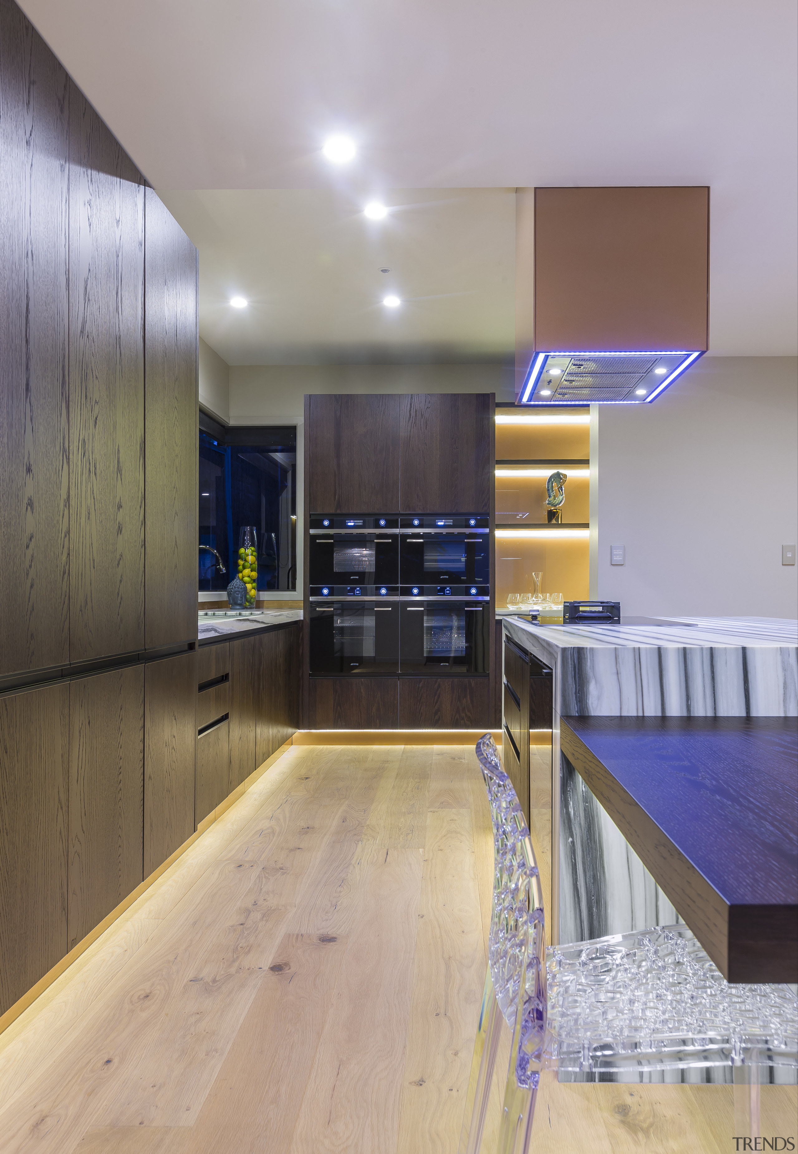 A bank of four black Smeg ovens is apartment, architecture, ceiling, countertop, floor, flooring, hardwood, house, interior design, kitchen, real estate, room, wood, wood flooring, gray