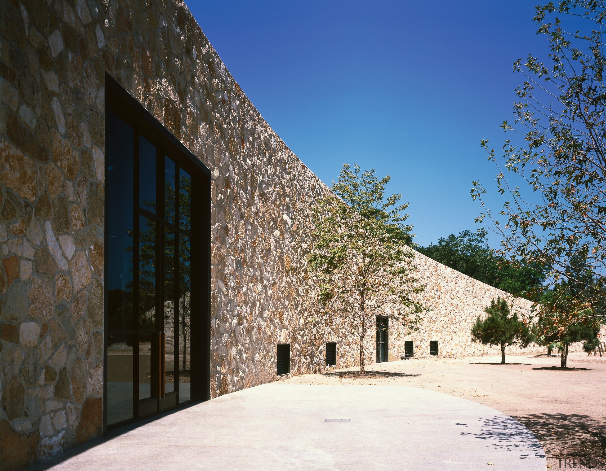 view of the symetrical stone facade wall that architecture, building, estate, facade, home, house, property, real estate, sky, tree, wall, black