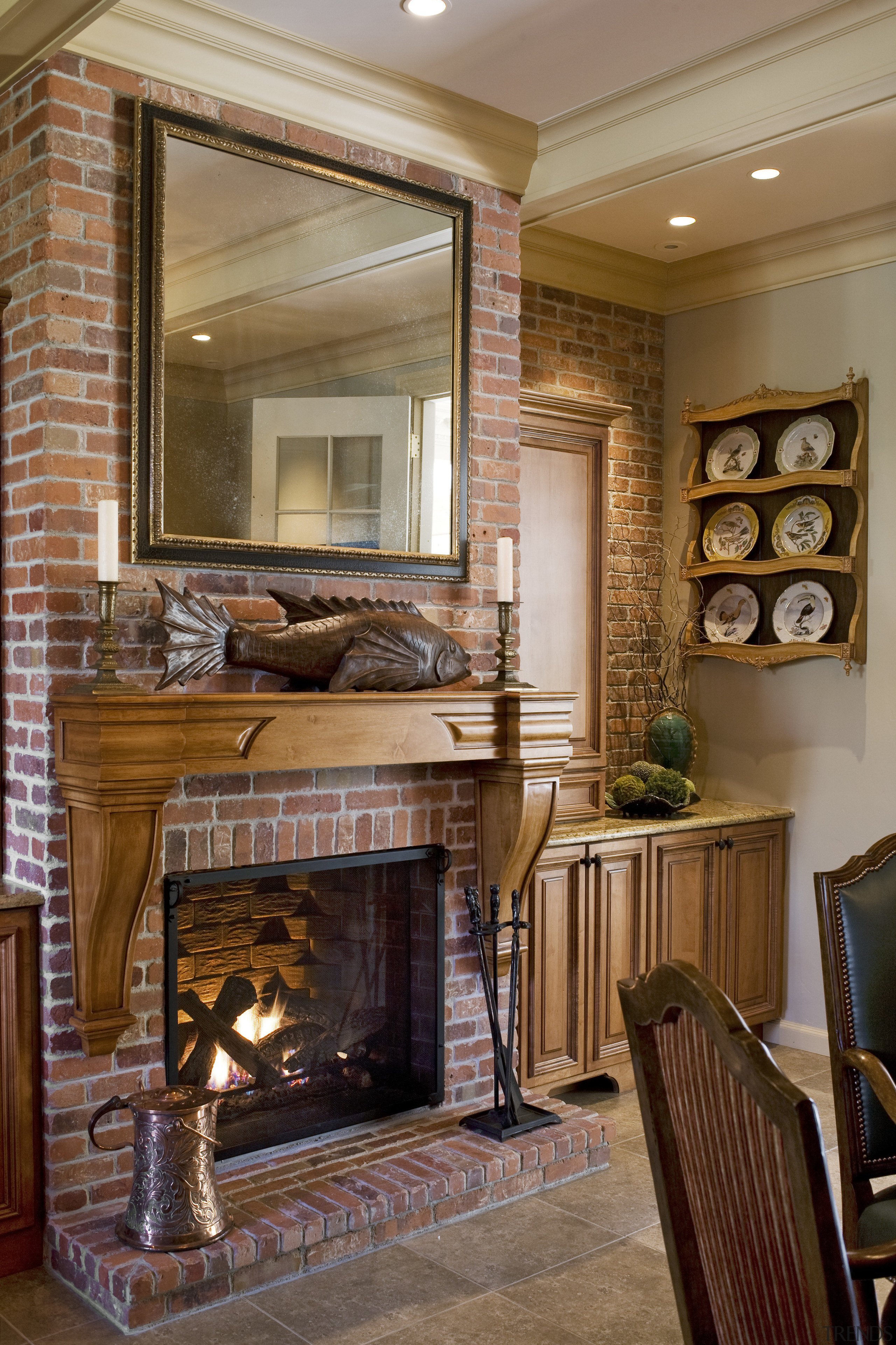 View of a traditional European-styled kitchen area which cabinetry, ceiling, fireplace, furniture, hearth, home, interior design, living room, lobby, room, wall, brown