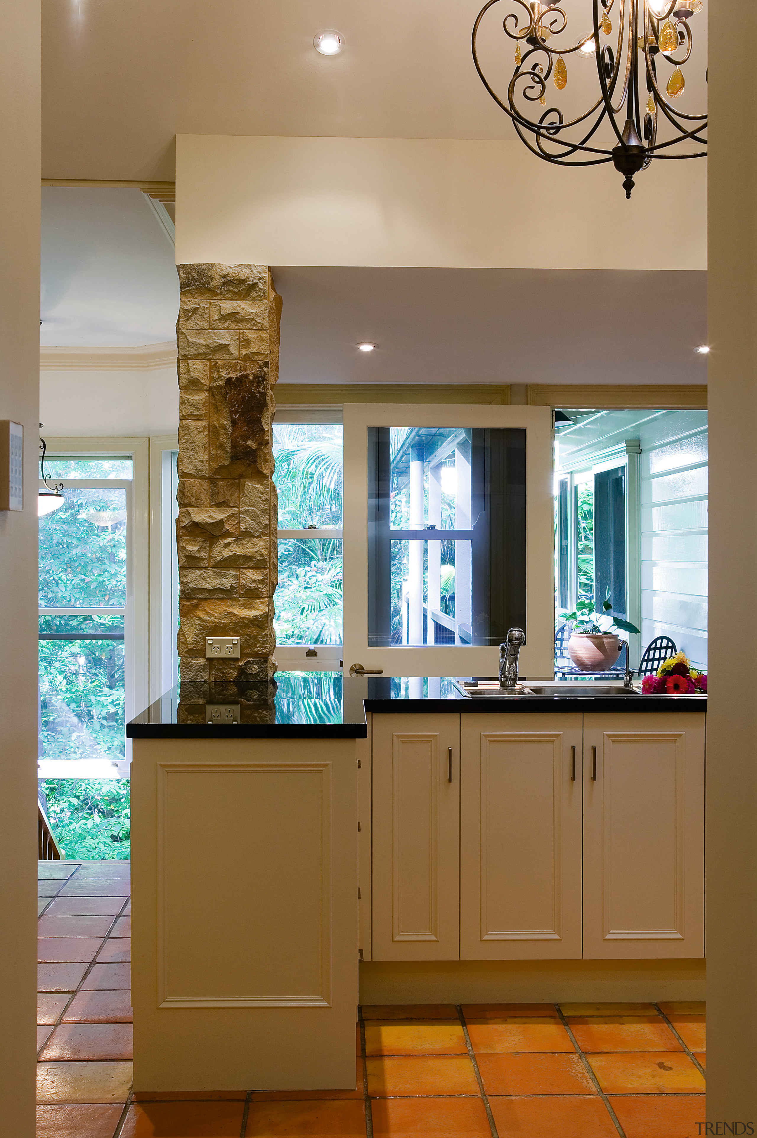 view of this french influenced kitchen featuring black cabinetry, ceiling, countertop, floor, flooring, home, interior design, kitchen, room, wall, window, brown