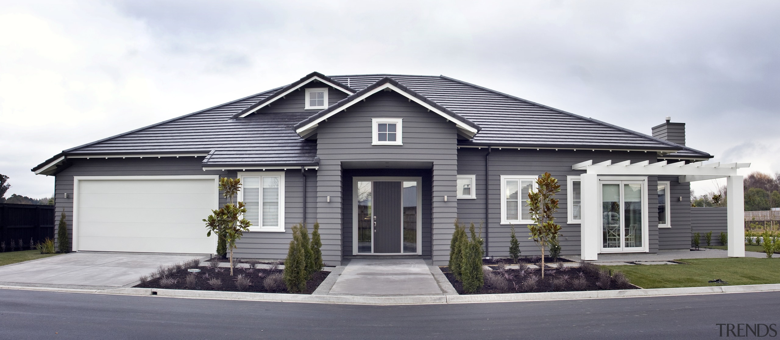 Exterior view of a Landmark Homes show home building, cottage, elevation, estate, facade, home, house, neighbourhood, property, real estate, residential area, siding, suburb, white, gray