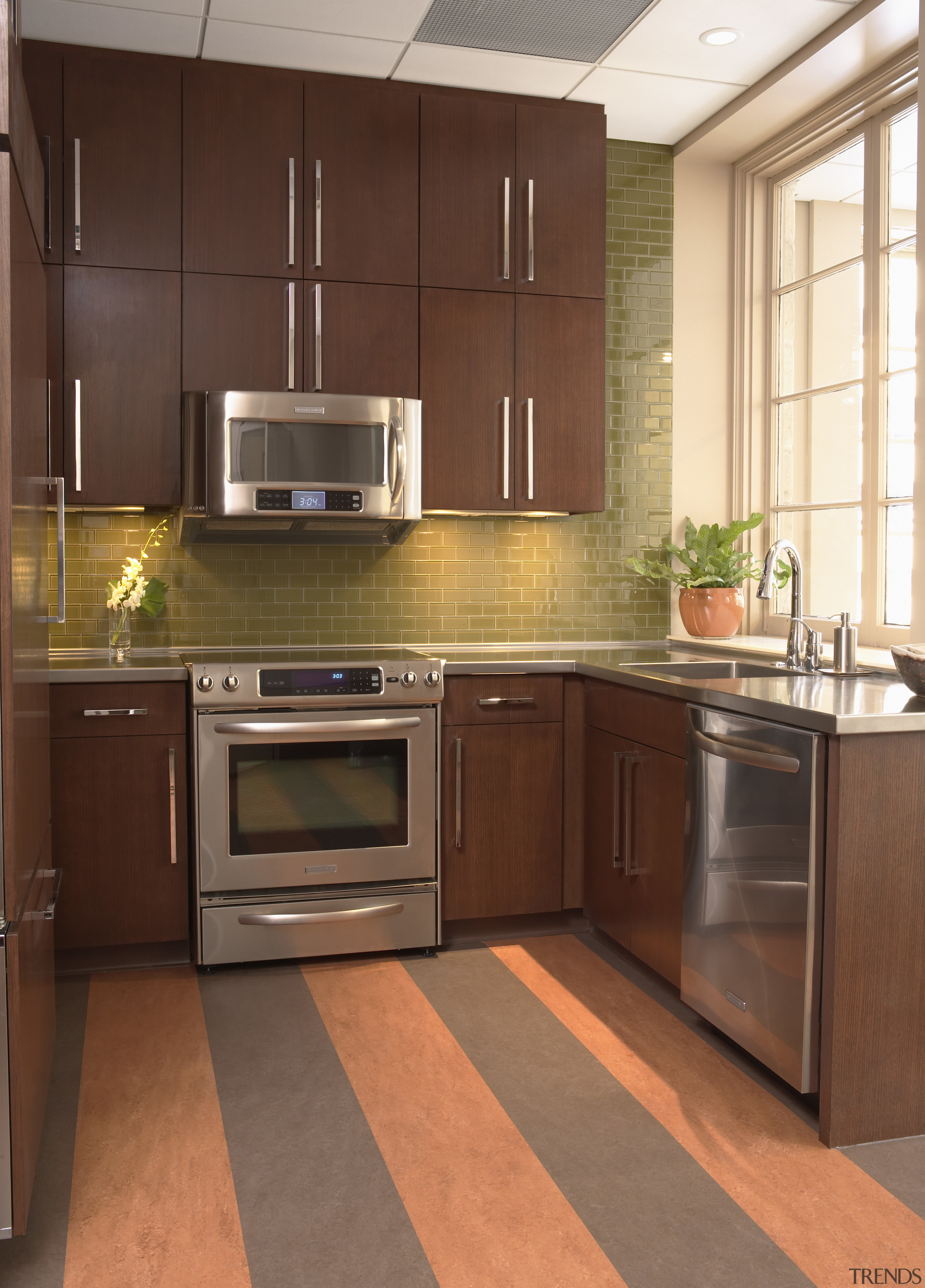 View of the office kitchen with appliances, cabinetry, cabinetry, countertop, cuisine classique, floor, flooring, hardwood, interior design, kitchen, room, wood flooring, brown