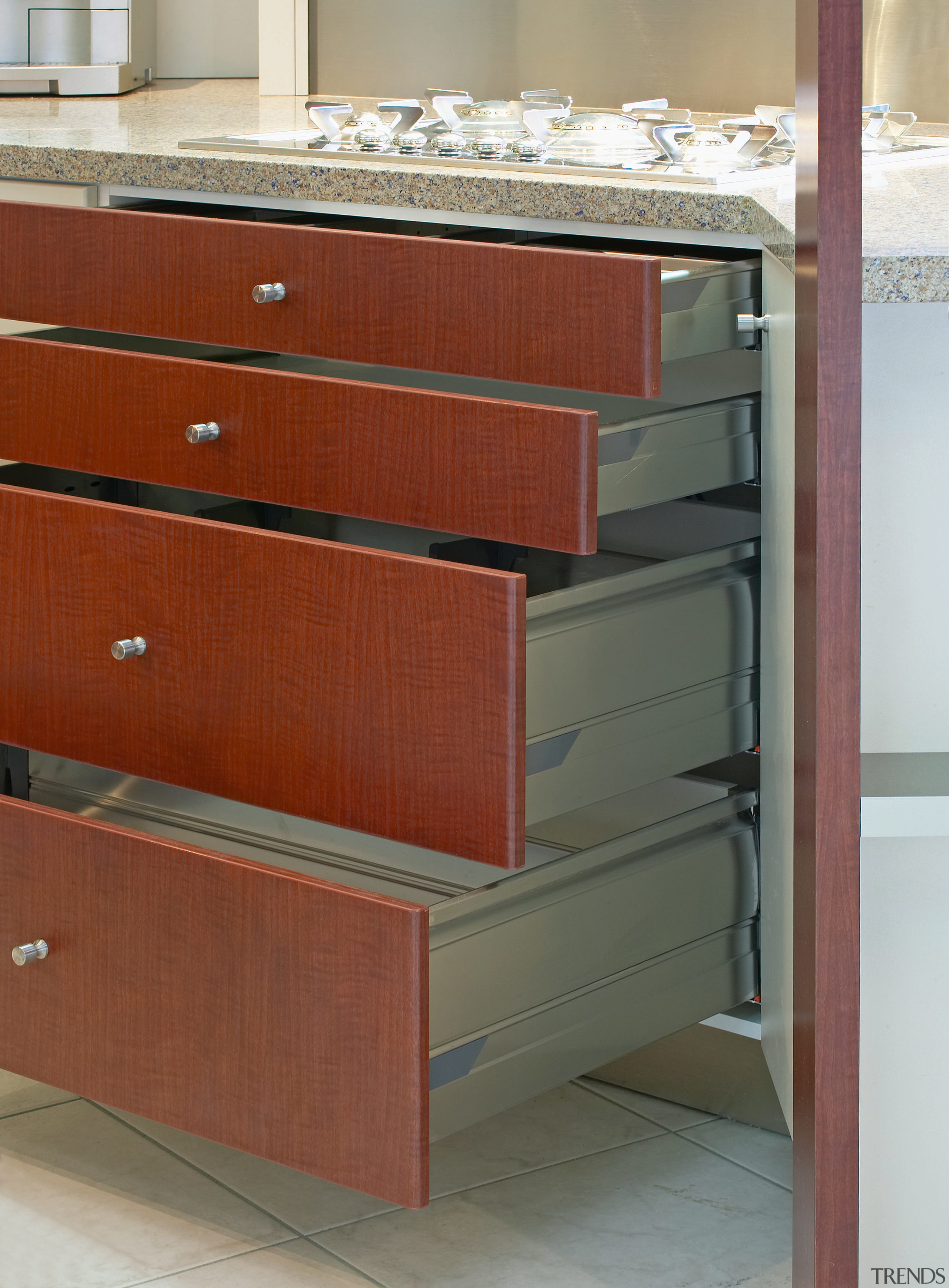 Kitchen with marble benchtops, showing brown drawers. cabinetry, chest of drawers, drawer, filing cabinet, floor, furniture, hardwood, plywood, product, shelf, wood, wood stain, red, gray