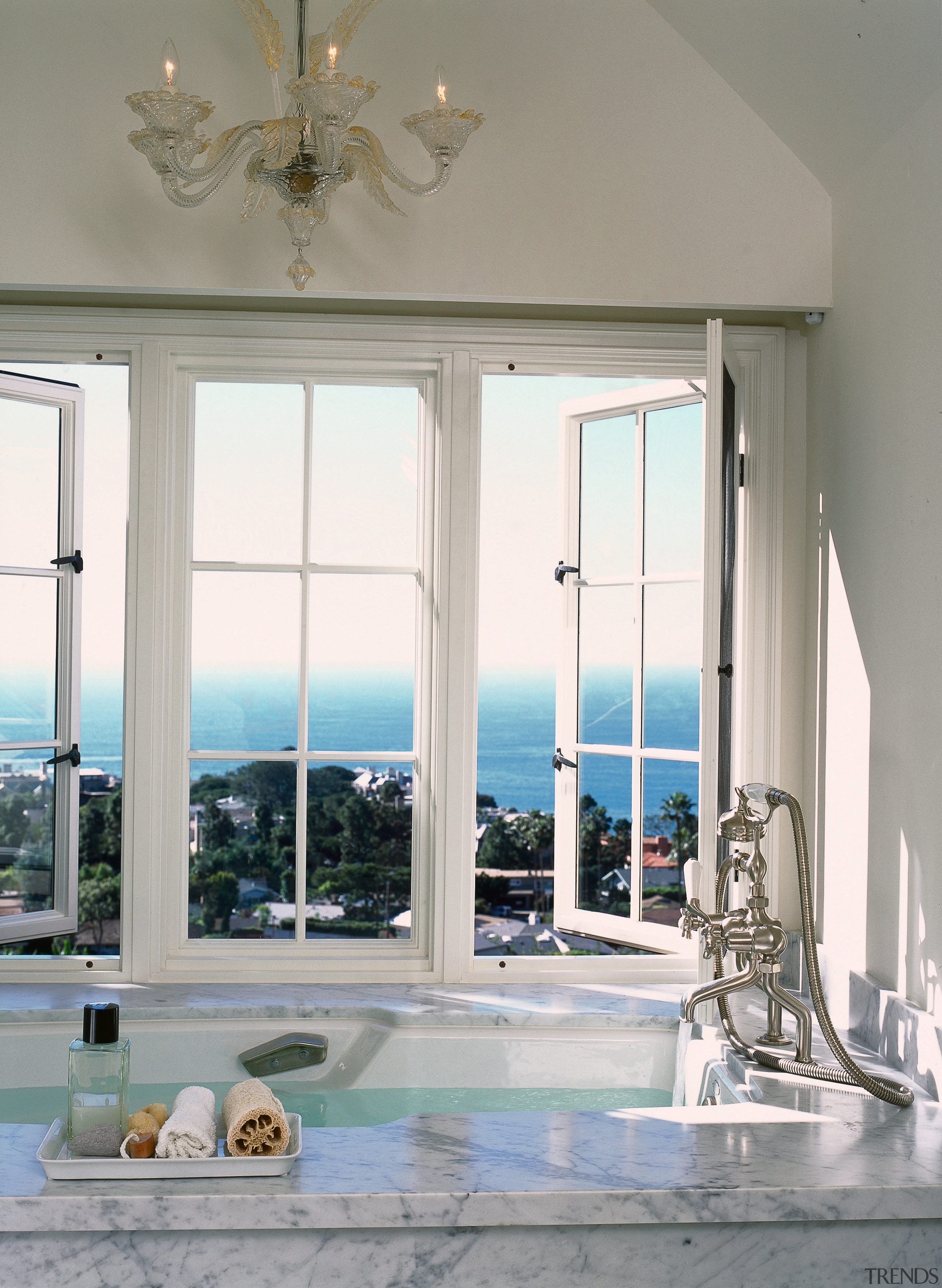 view of this bathroom featuring featuring raised bathtub ceiling, daylighting, door, estate, home, interior design, living room, structure, window, gray, white