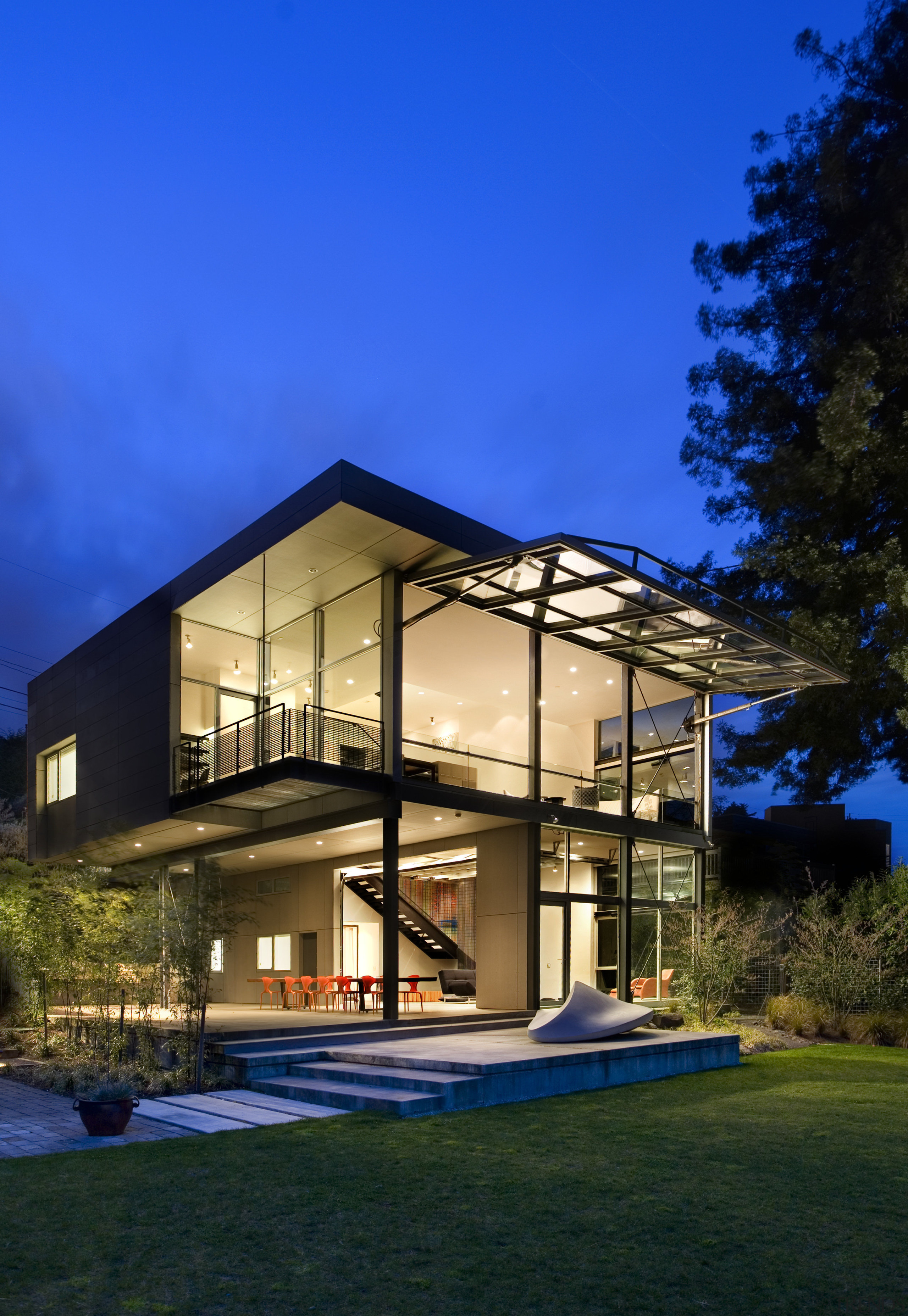 Exterior night shot of sculptural home. - Exterior architecture, building, cottage, elevation, estate, facade, home, house, landscape lighting, lighting, property, real estate, residential area, sky, villa, window, blue