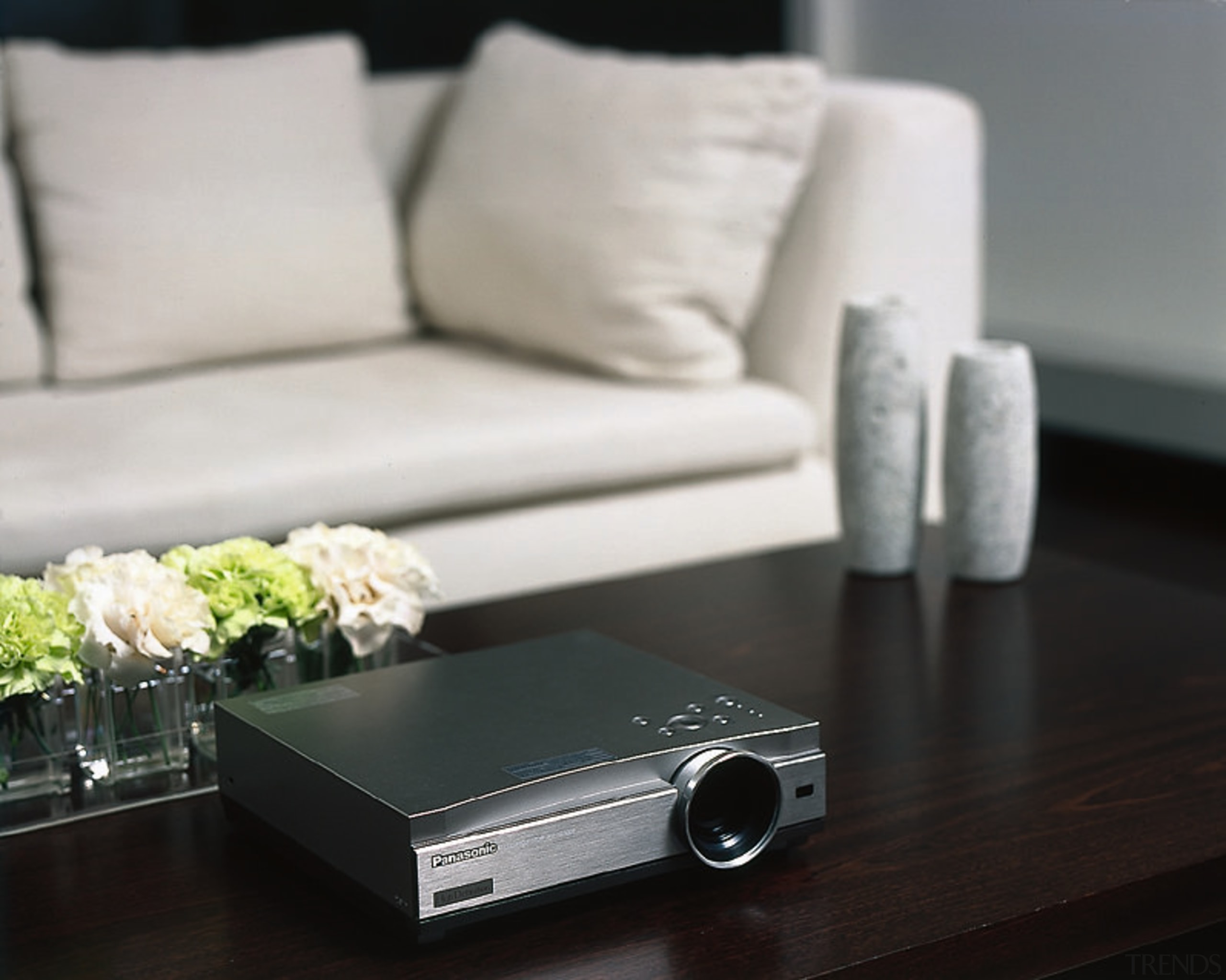 A photograph of a Panasonic PT-AE500 projector - coffee table, floor, flooring, furniture, product design, table, gray, black