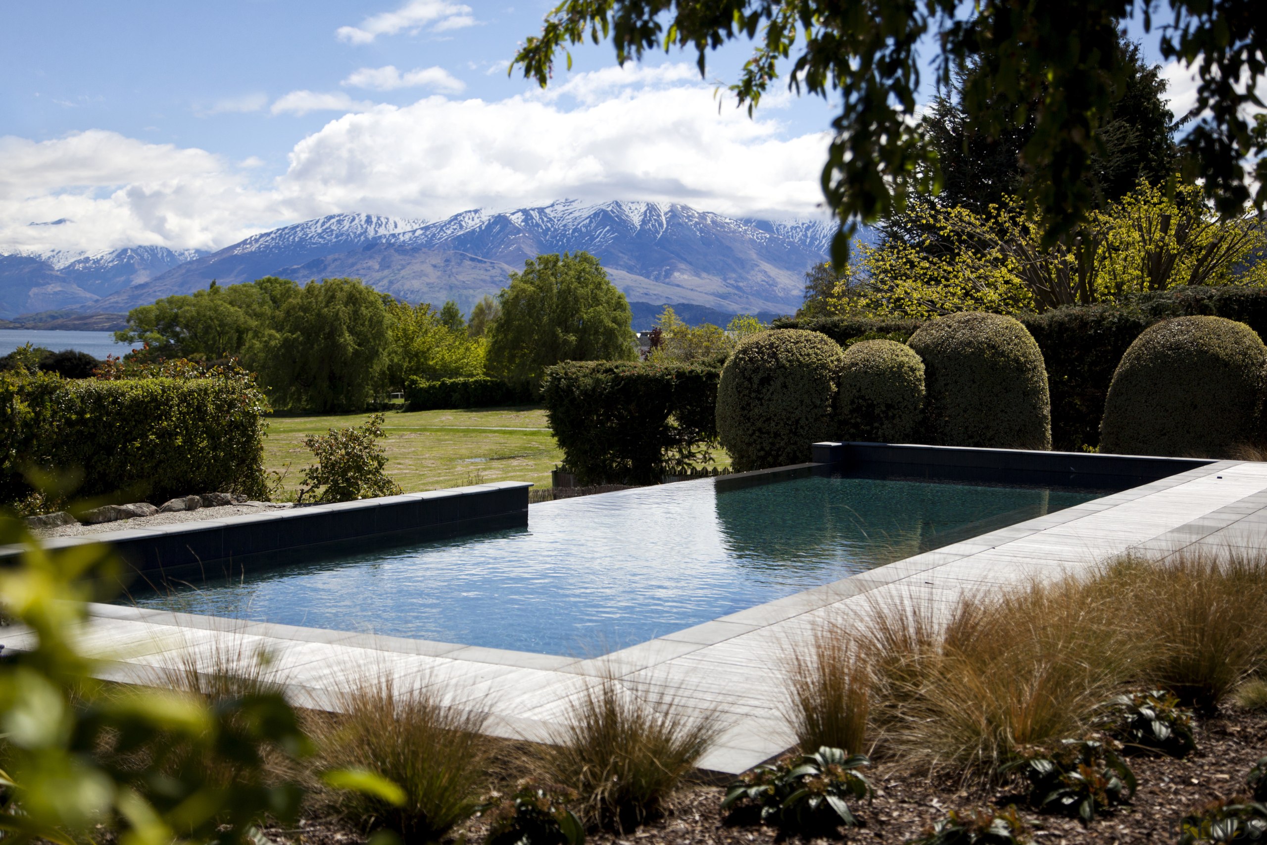 View of pool and landscaping. - View of estate, landscape, leisure, property, real estate, reflection, sky, swimming pool, tree, water, brown