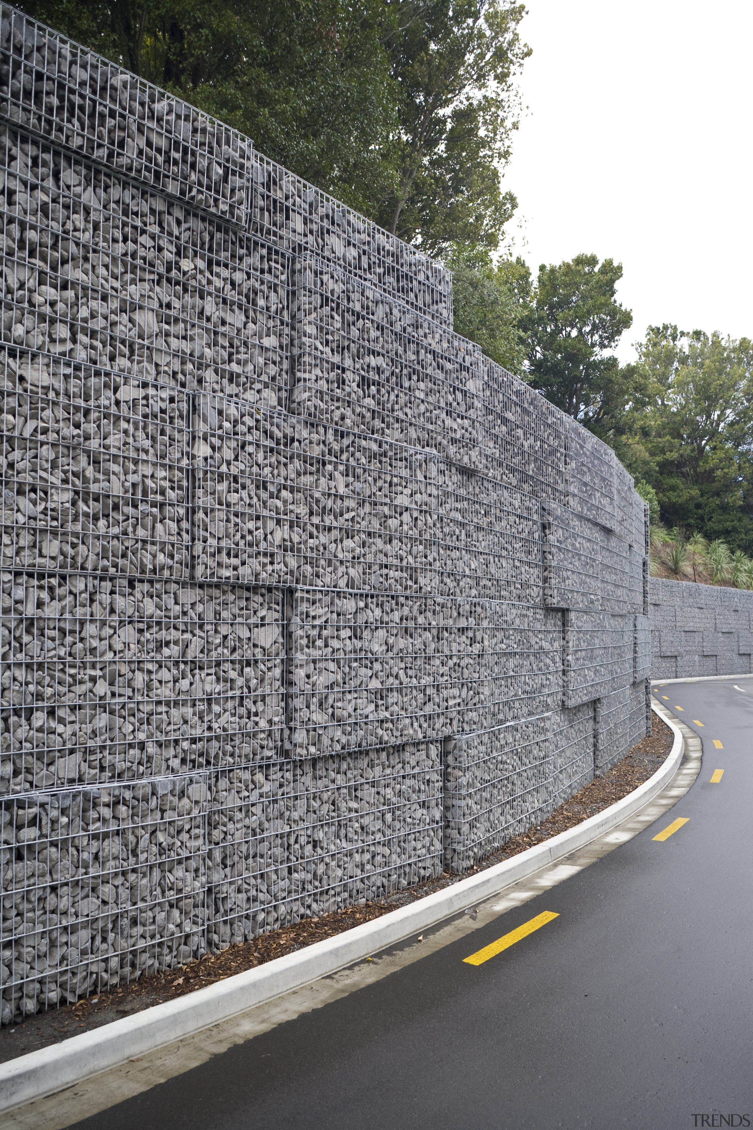 View of a large retaining wall with a infrastructure, road surface, stone wall, wall, gray