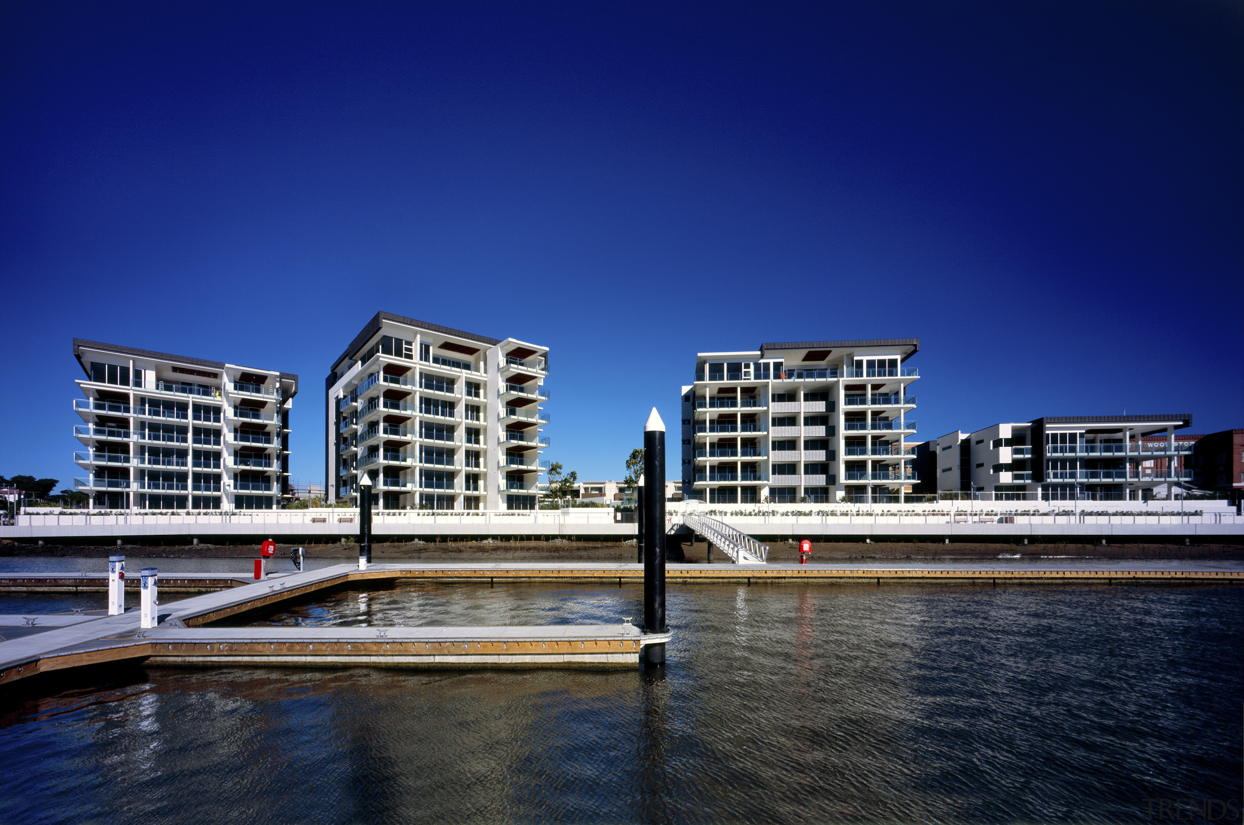 View of the exterior of the four buildings architecture, building, city, cityscape, condominium, corporate headquarters, daytime, metropolis, mixed use, real estate, reflection, residential area, sky, tower block, urban area, water, waterway, blue
