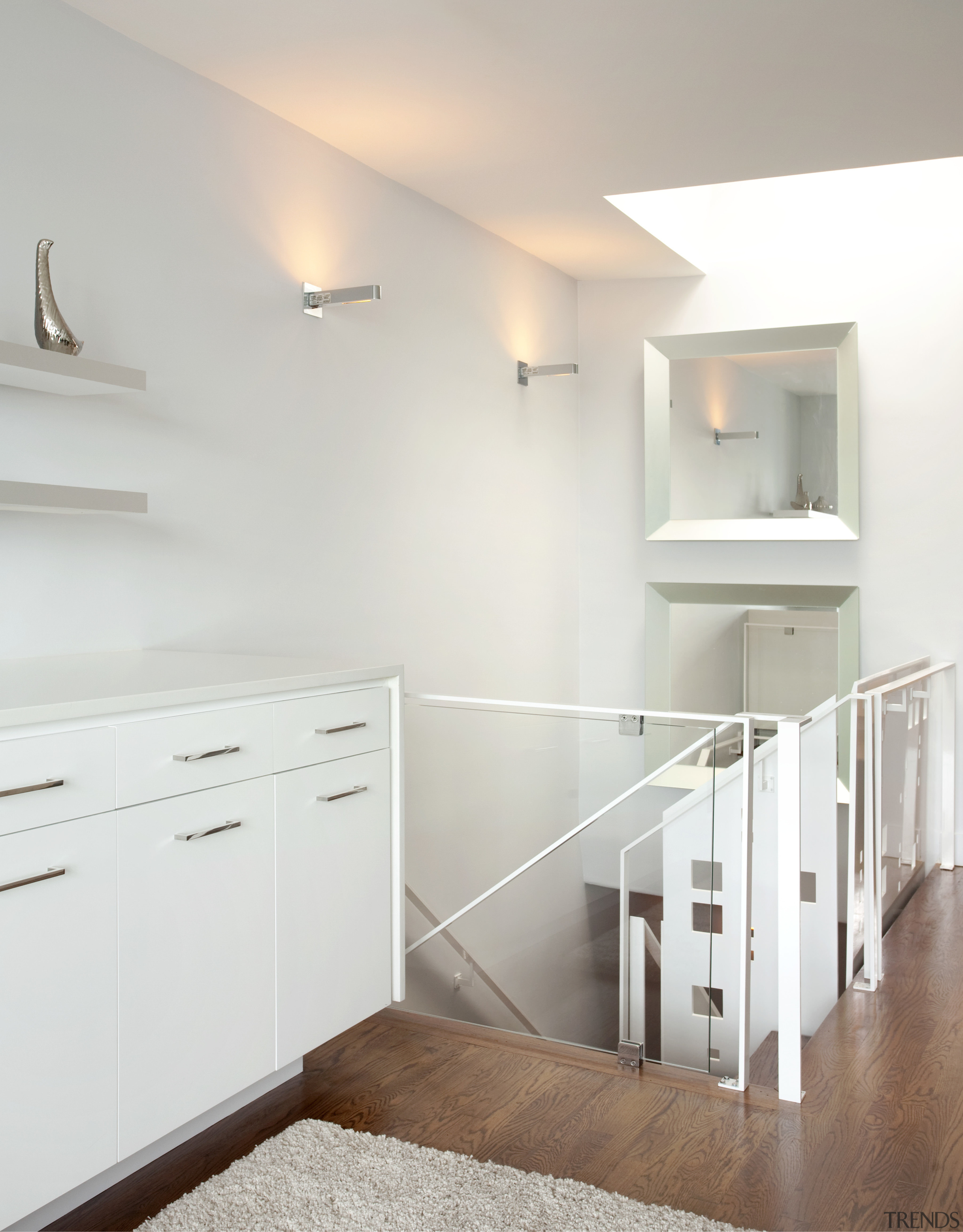 Light from a large skylight floods the stairwell cabinetry, chest of drawers, daylighting, floor, flooring, furniture, handrail, home, interior design, product, product design, real estate, room, shelf, wall, wood, wood flooring, gray, white