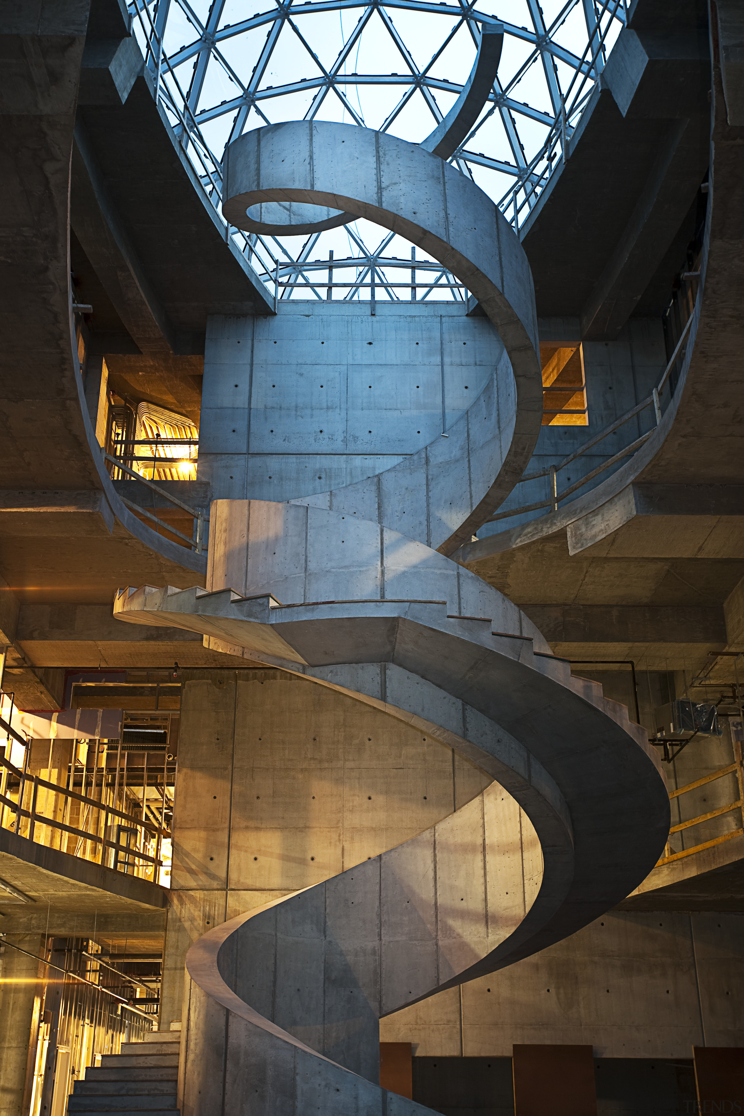 A dramatic spiral concrete staircase is a feature architecture, building, daylighting, landmark, sky, stairs, structure, symmetry, tourist attraction, black, brown