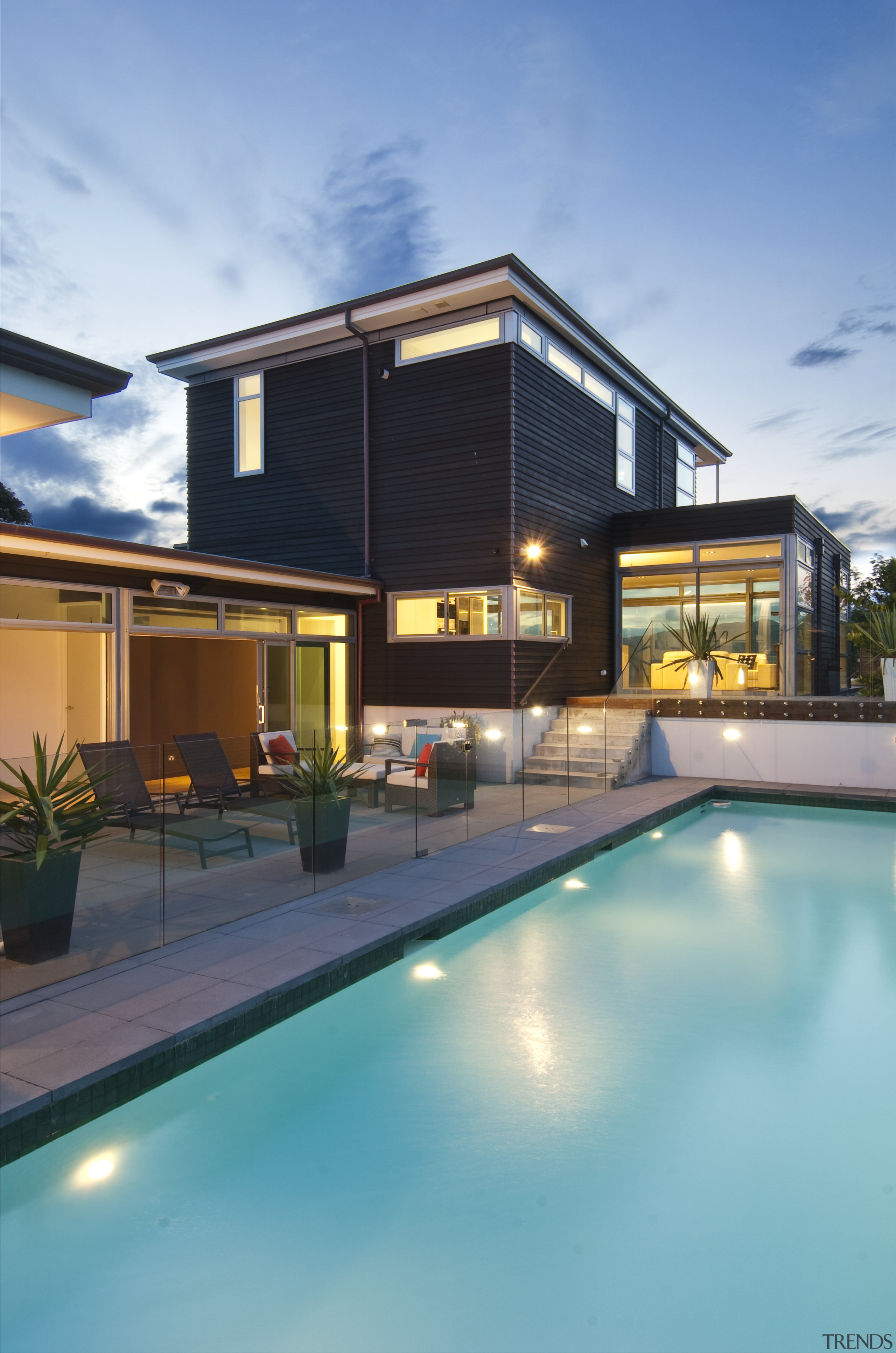 Evening view of this modern home features pool, architecture, estate, home, house, leisure, leisure centre, property, real estate, reflection, residential area, sky, swimming pool, villa, water, teal