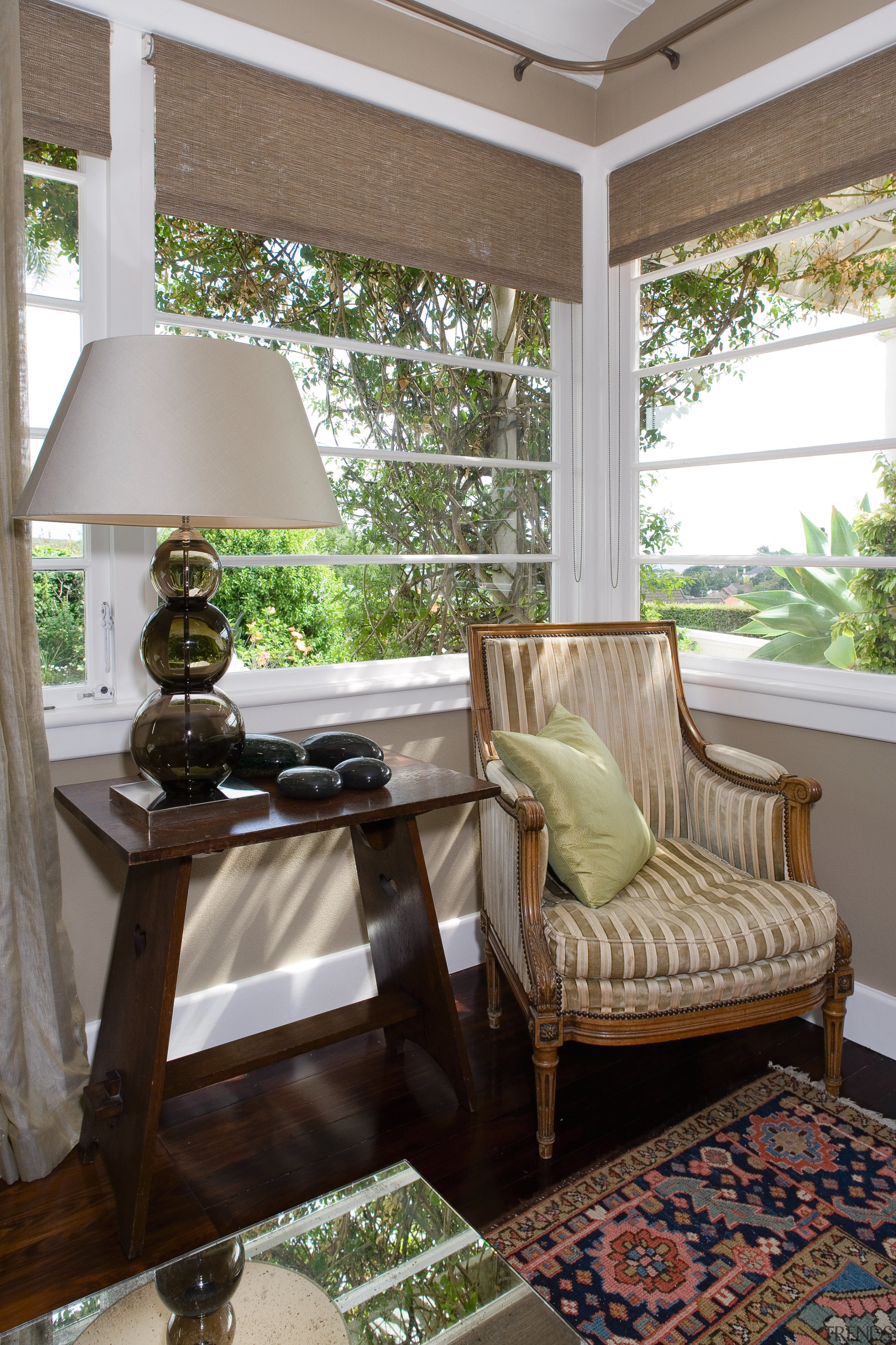 A view of this upholstered chair, glass lampstand chair, furniture, home, house, interior design, living room, porch, room, table, window, window covering, window treatment, gray