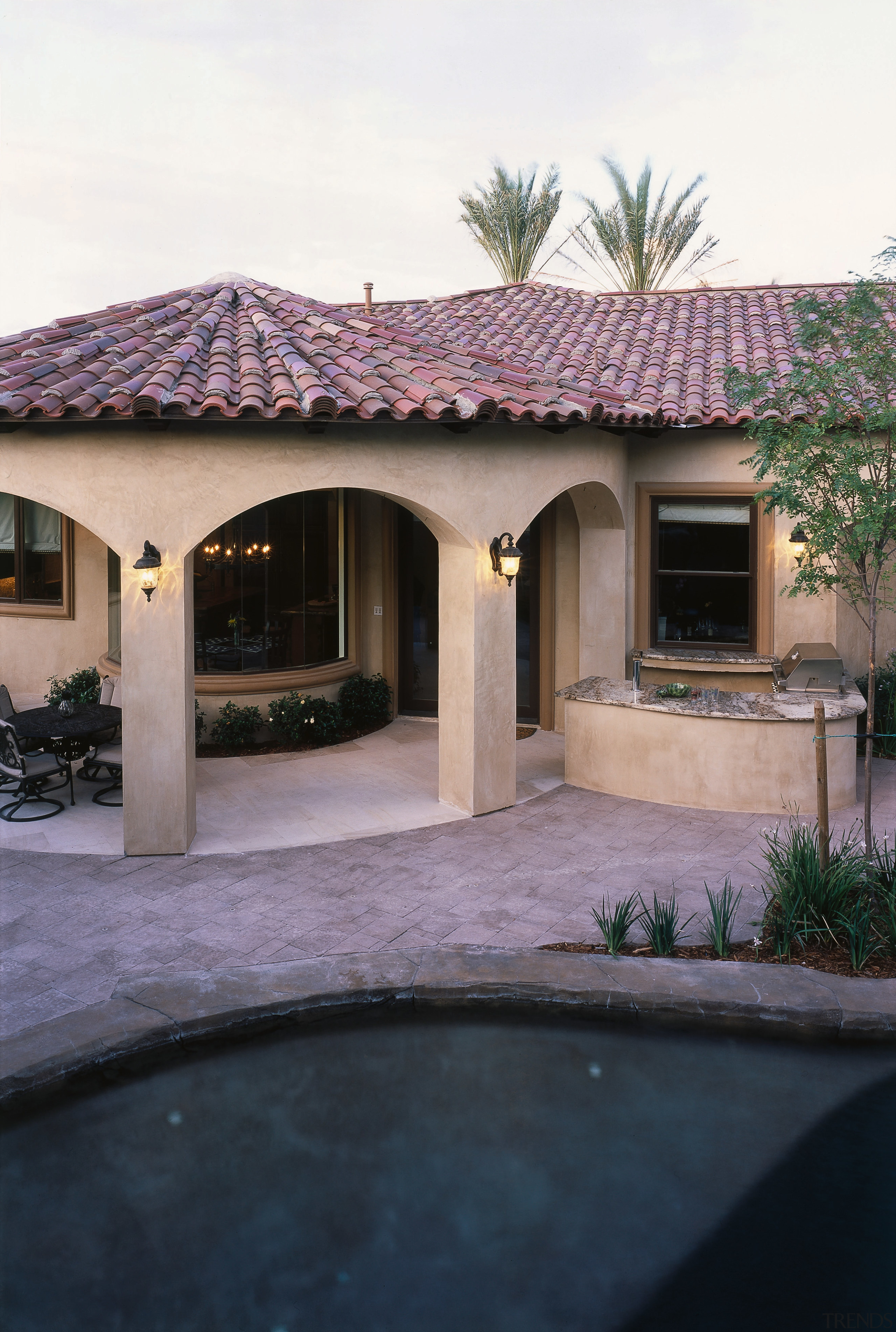 view of the clay tile roofing on this backyard, estate, facade, hacienda, home, house, outdoor structure, property, real estate, residential area, roof, window, black, white