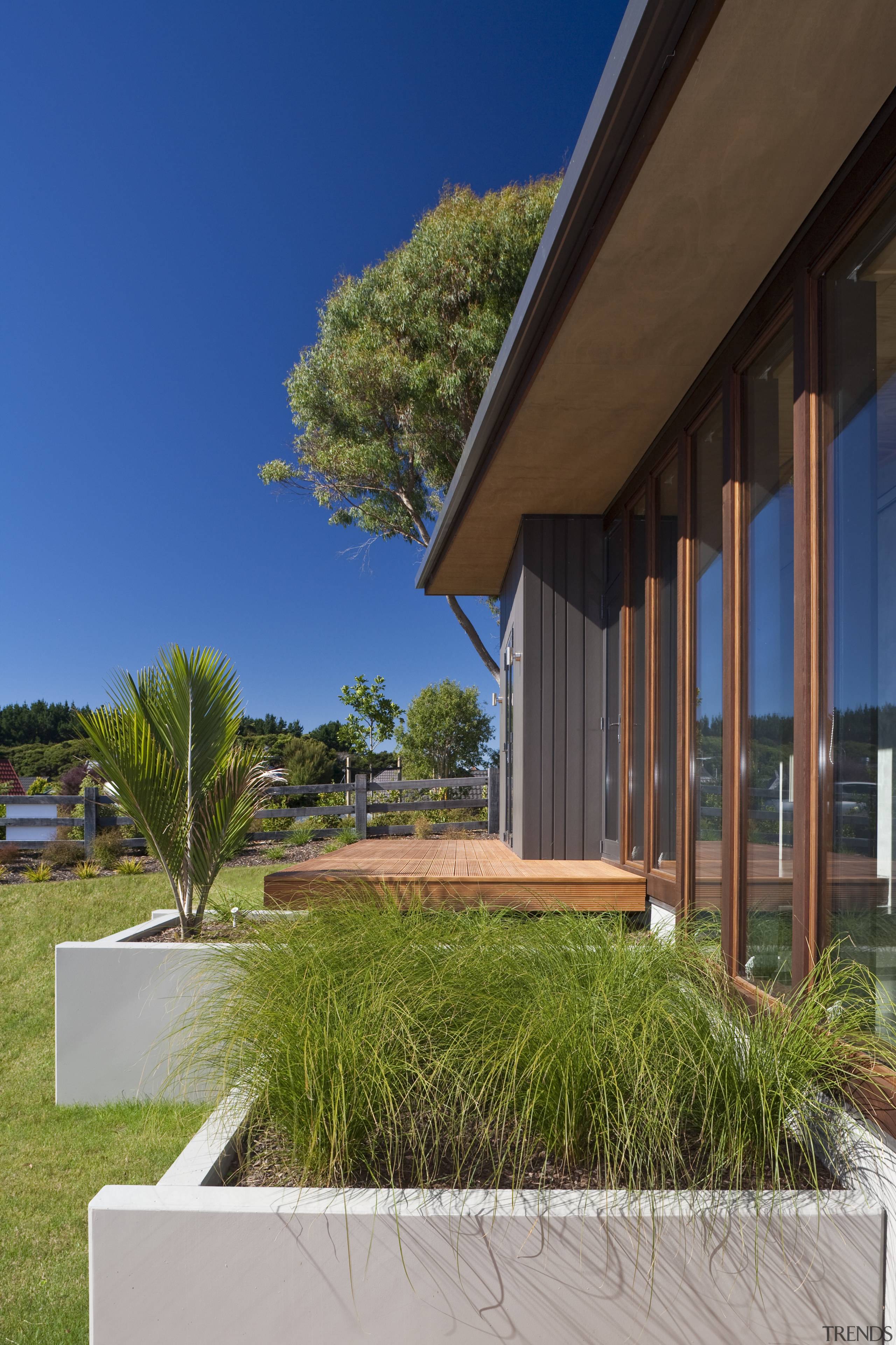 Exterior view of an energy-efficient home and gardens architecture, arecales, cottage, estate, facade, grass, home, house, palm tree, property, real estate, residential area, sky, villa, window, brown, blue