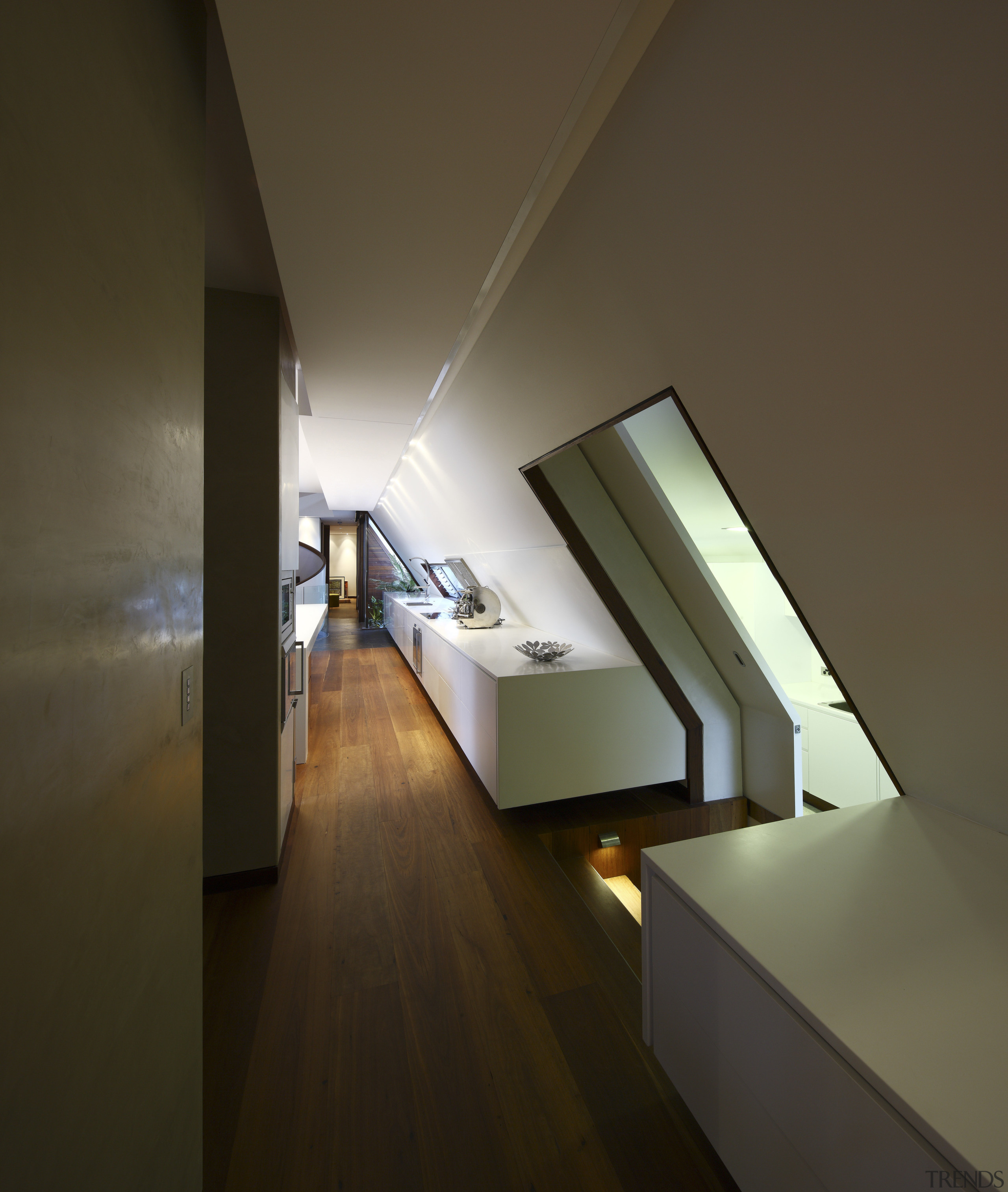 View of kitchen area featuring hardwood flooring, island apartment, architecture, ceiling, daylighting, floor, house, interior design, light, light fixture, lighting, product design, stairs, wood, brown