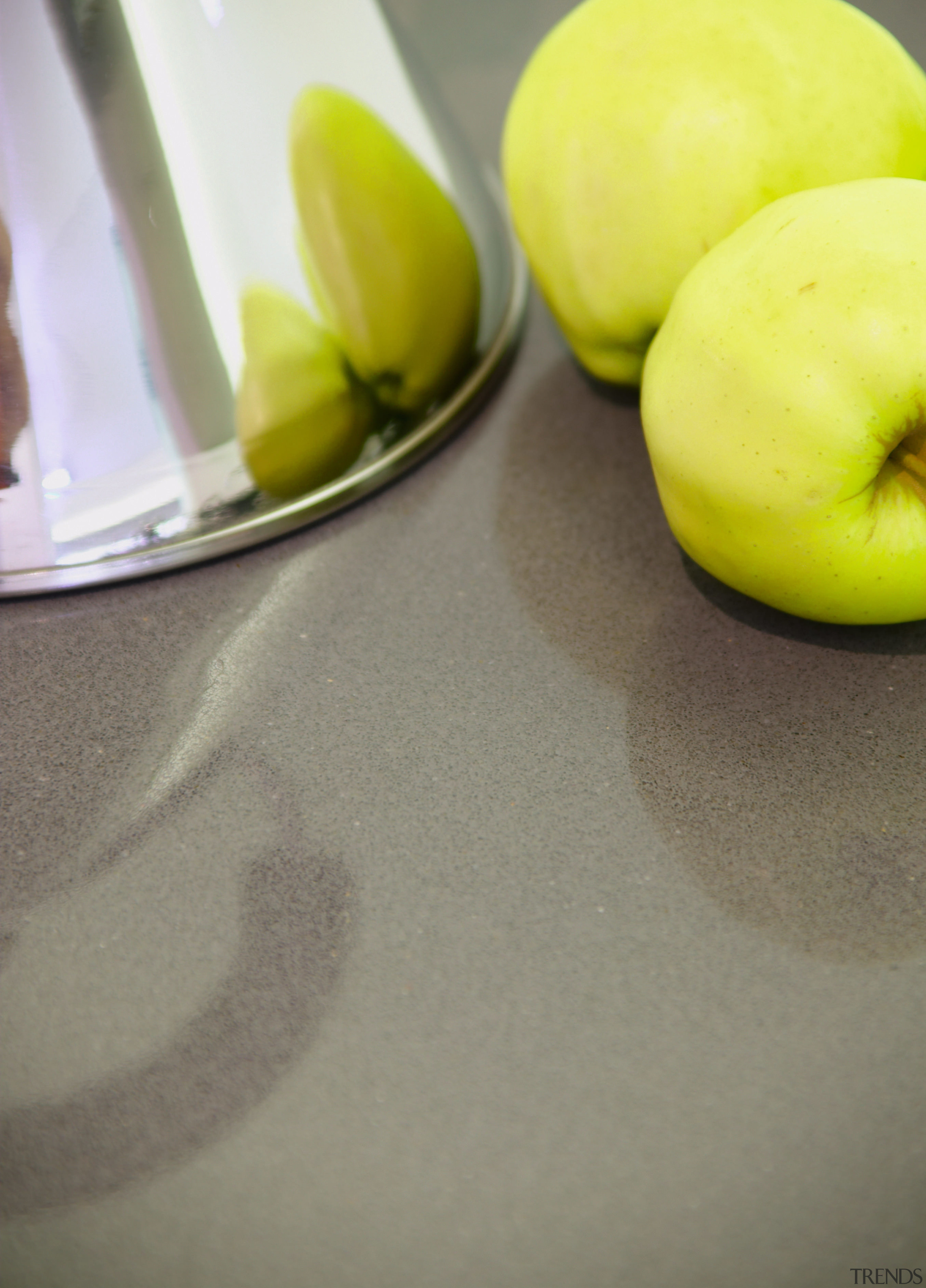 Dark grey benchtop with apples and kettle on apple, fruit, produce, still life photography, gray