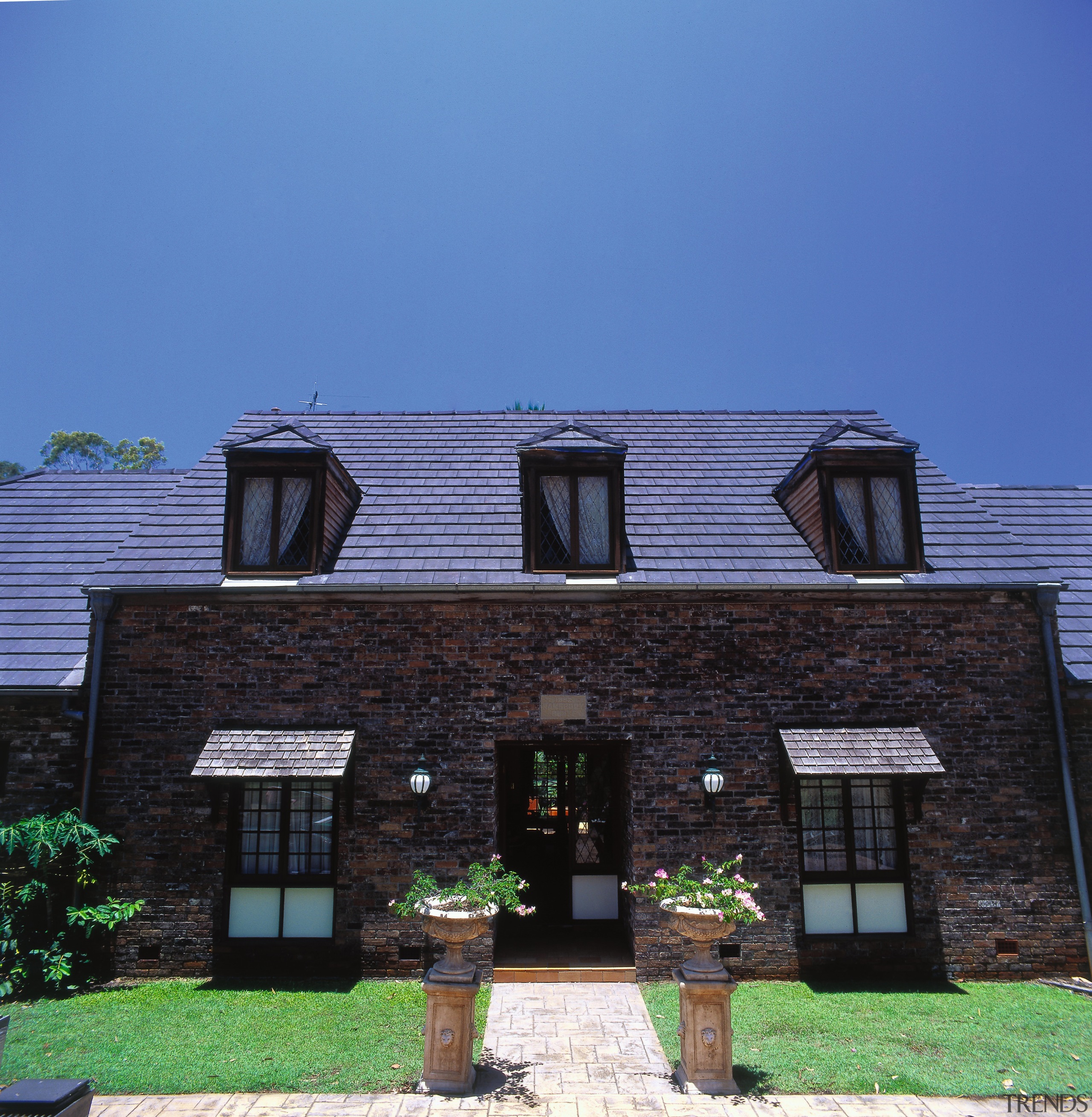 Exterior of house with aged brick cladding, steep architecture, building, cottage, elevation, facade, home, house, property, real estate, residential area, roof, siding, sky, suburb, window, blue, black