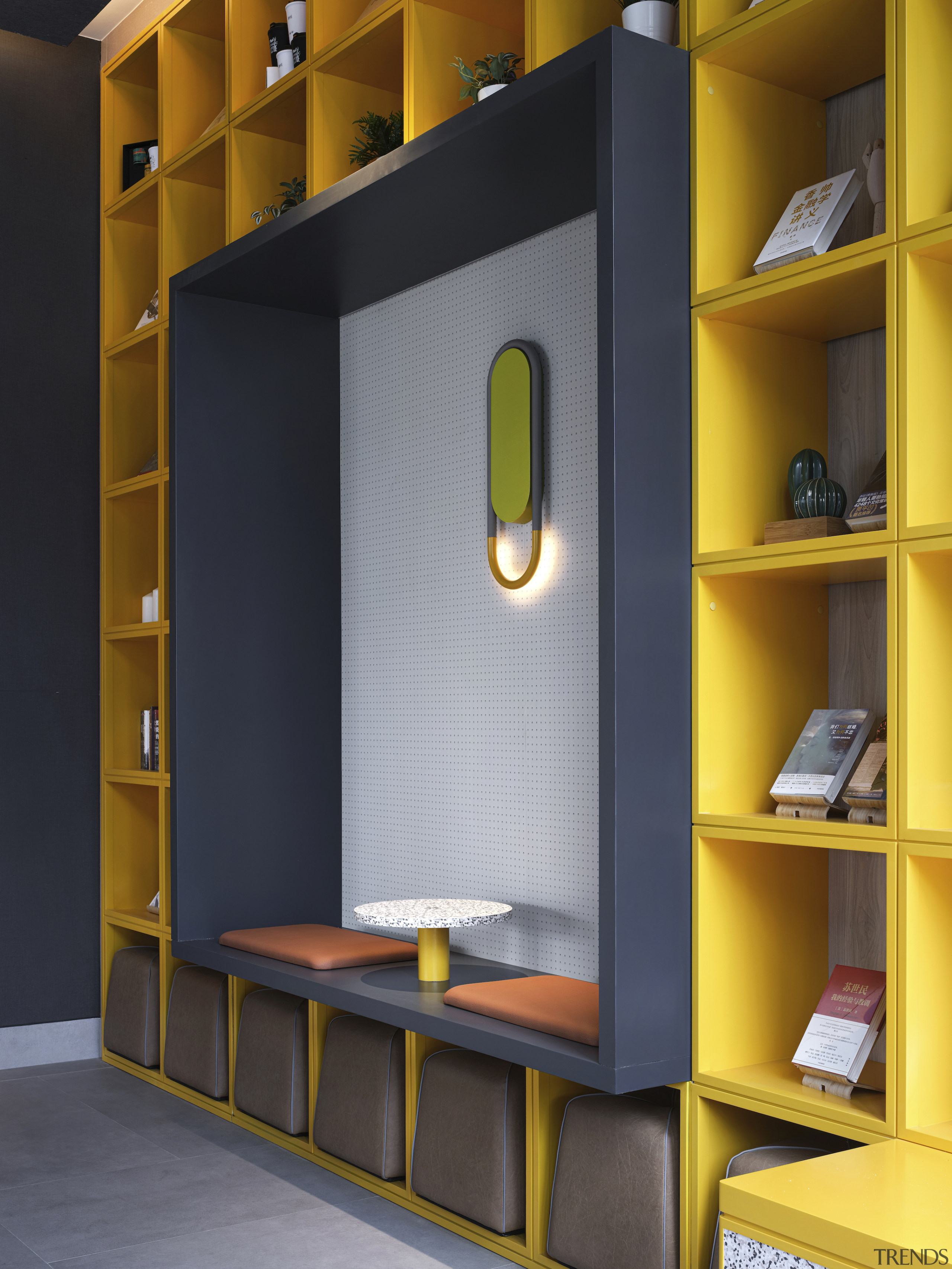 A striking yellow floor-to-ceiling book display wall with 